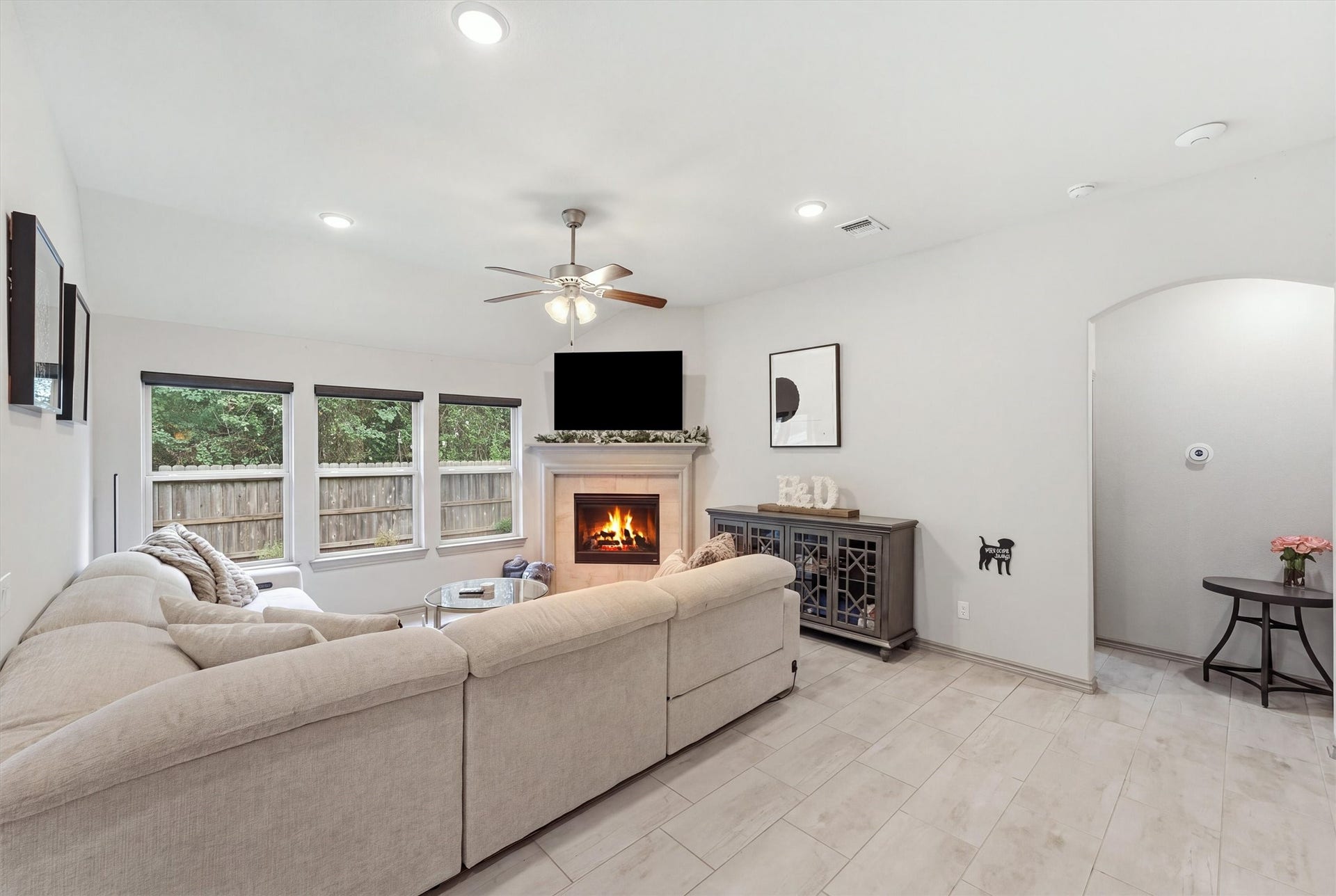 9726 Birdsnest Court, Spring, TX 77379 Spacious living room featuring a cozy fireplace, abundant natural light, and large windows overlooking the backyard.