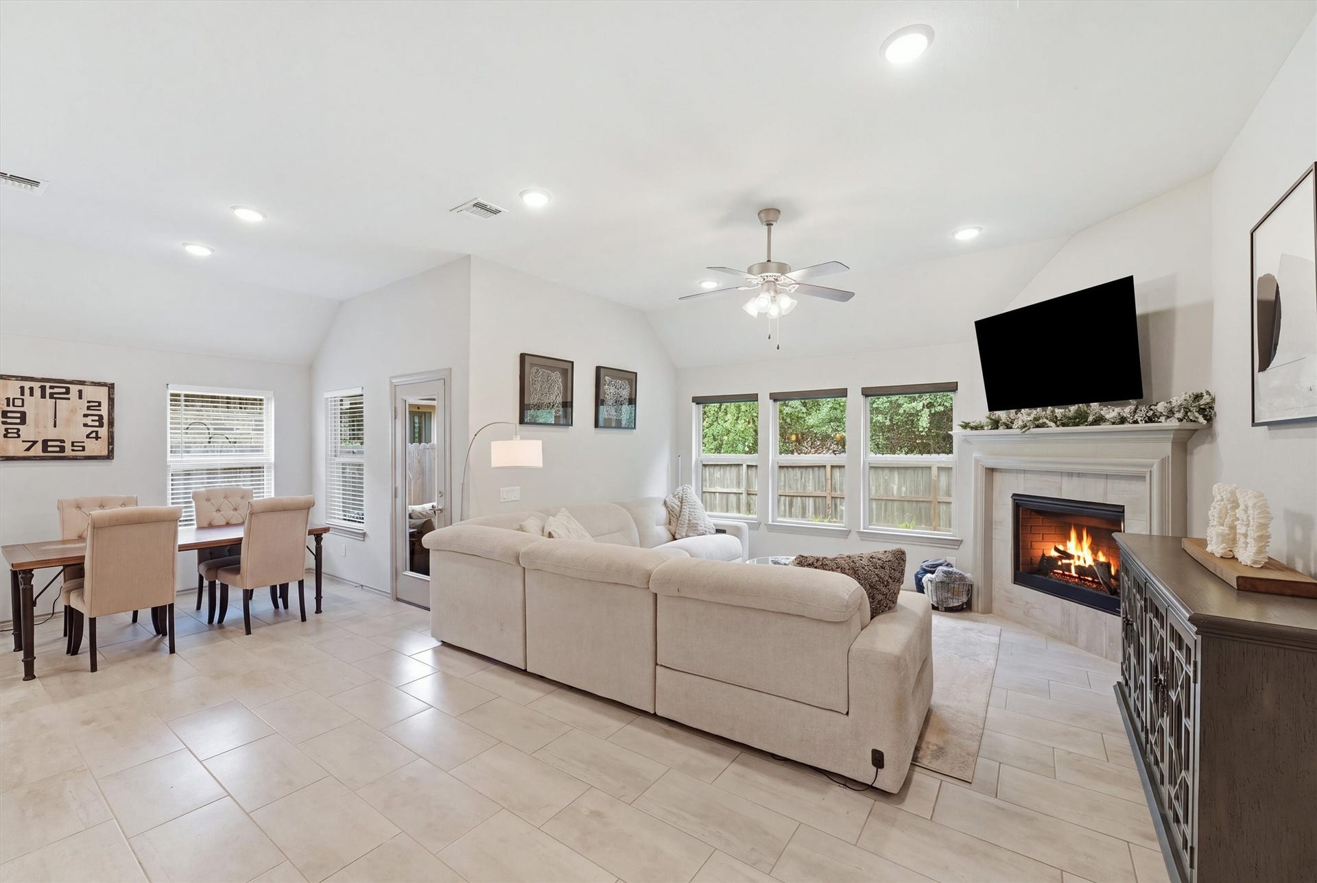 9726 Birdsnest Court, Spring, TX 77379 Open-concept living area featuring high ceilings, a comfortable seating arrangement, fireplace, and seamless connection to the dining area.