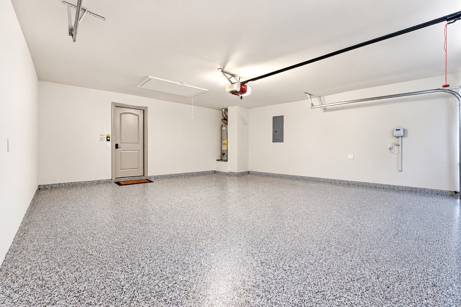 9726 Birdsnest Court, Spring, TX 77379 Spacious two-car garage featuring durable epoxy-coated flooring, a clean finished interior, and ample room for parking, storage, and organization.