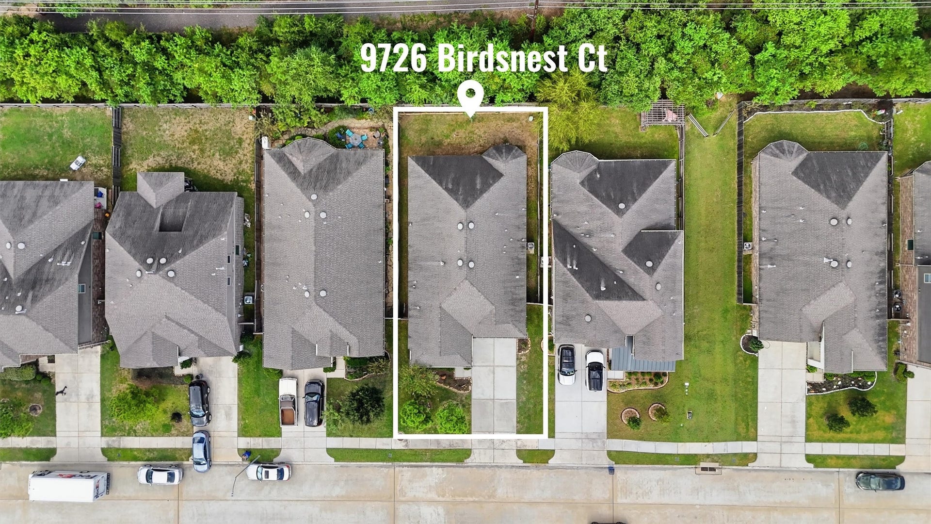 9726 Birdsnest Court, Spring, TX 77379 Overhead aerial view highlighting the home's lot, driveway, and backyard, with a wooded greenbelt beyond the rear fence.