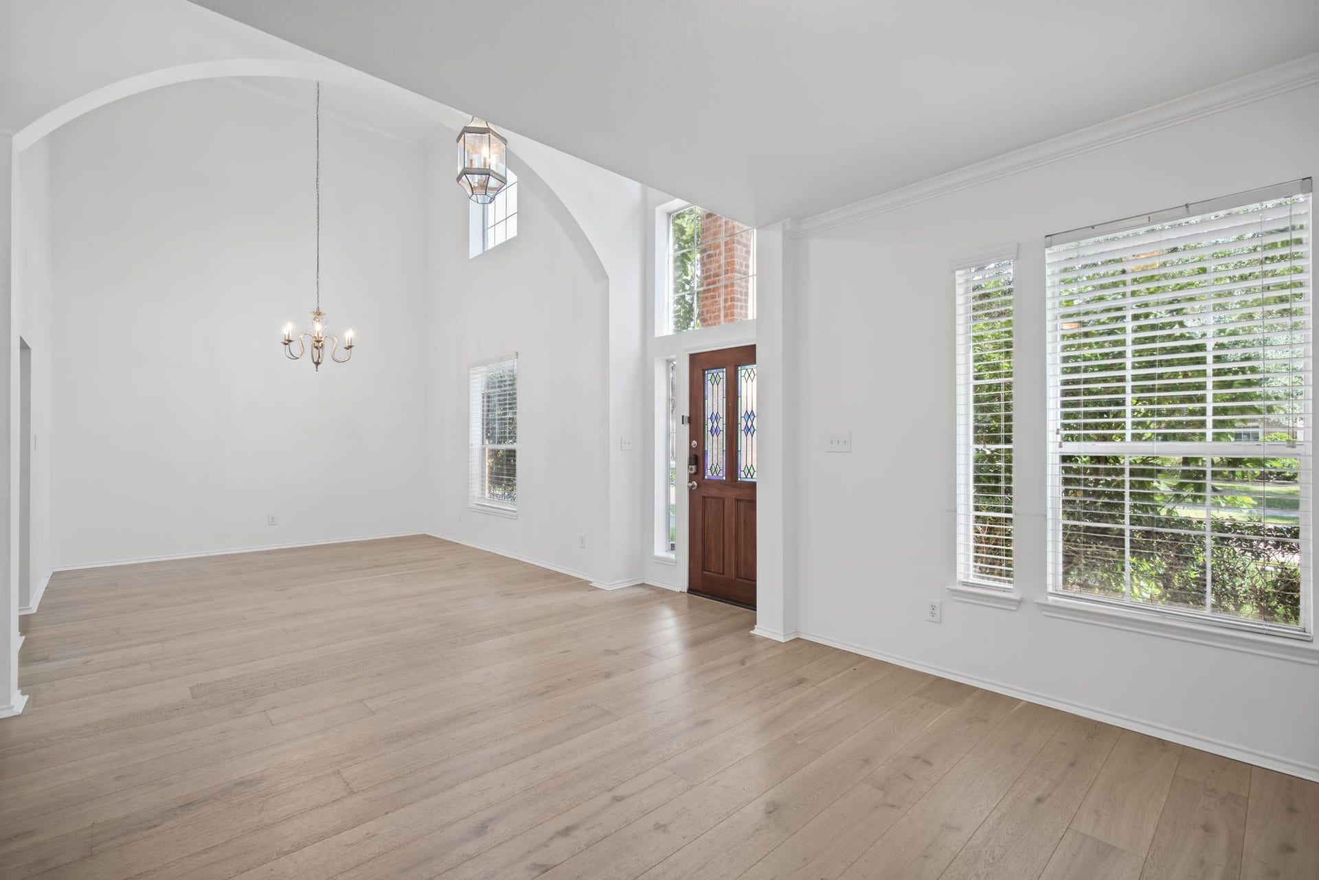 In the formal living room, a generous window brings soft natural light across the flooring, creating an elegant setting for conversation.