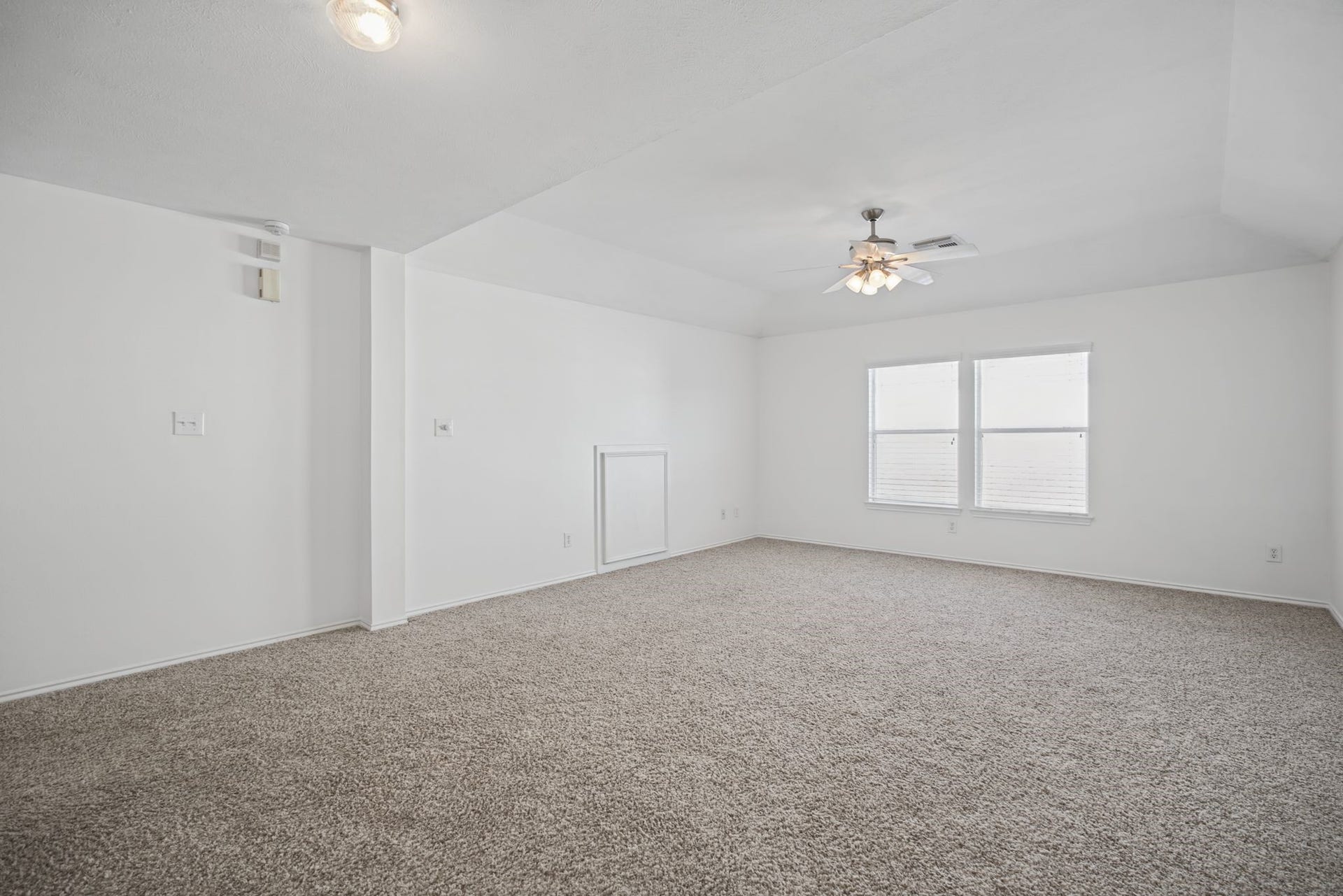A wider perspective illuminates the game room's generous open floor space.