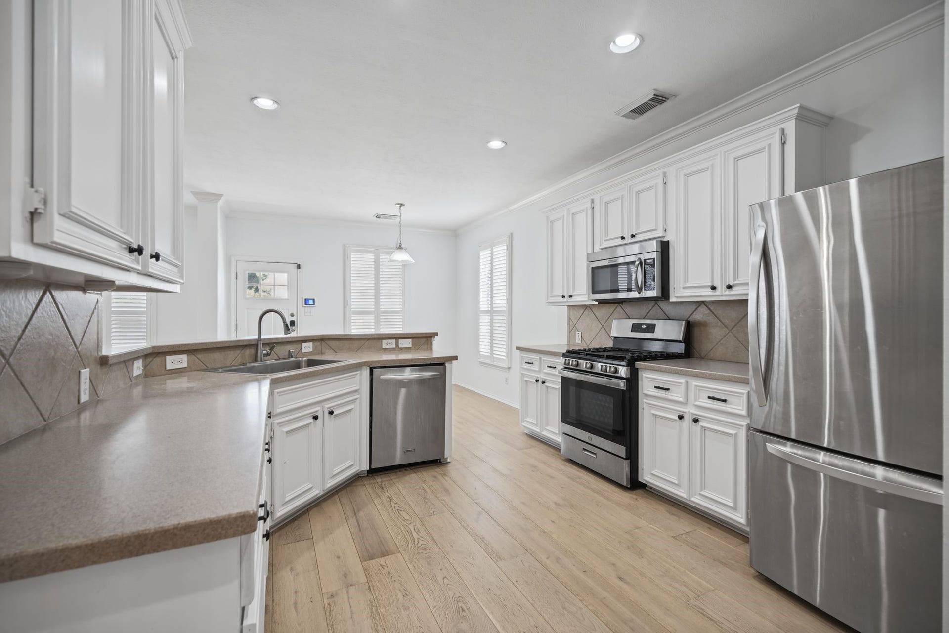 Explore the kitchen, where white cabinetry, extensive counter space, and stainless-finish appliances create a polished and practical workspace. Fridge included.