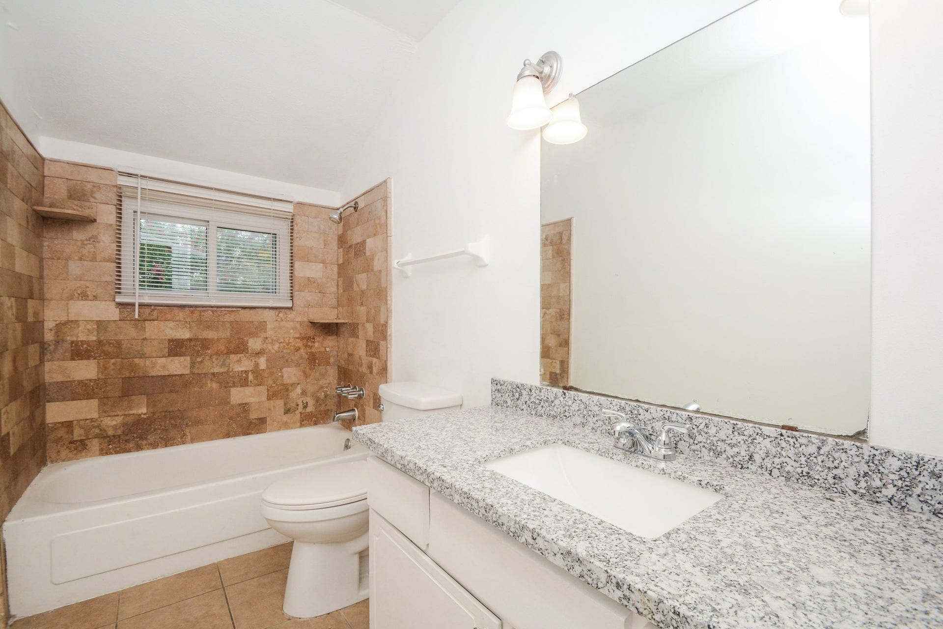 Designer tile bathtub with granite countertop.