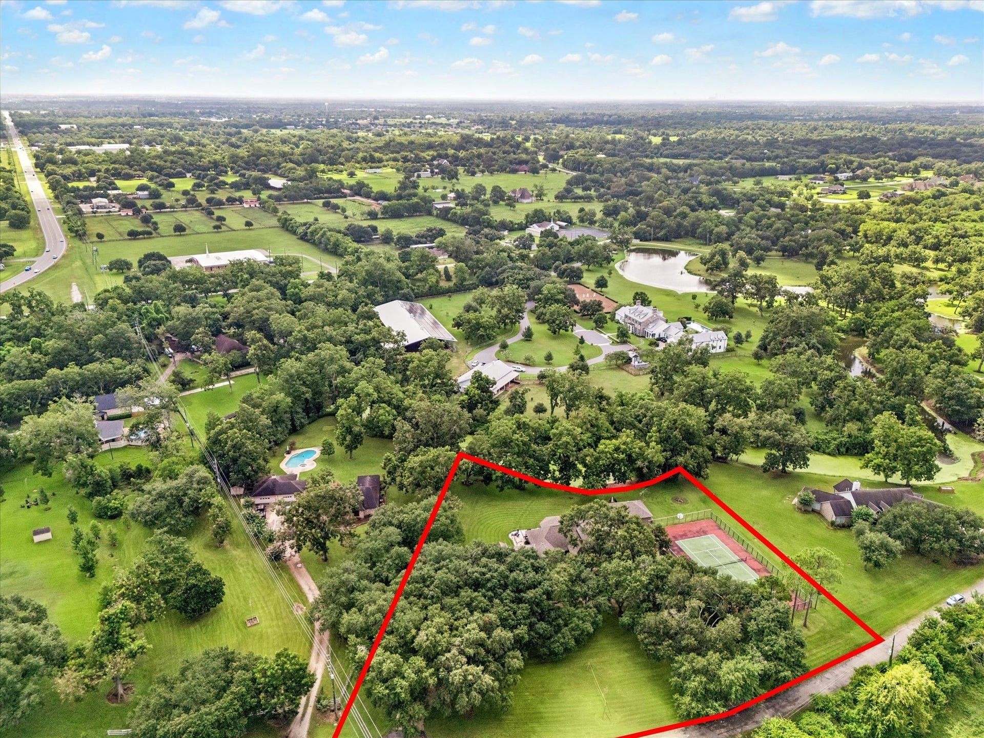 2020 PECAN LAKE DRIVE, Richmond, TX 77406 AERIAL VIEW HIGHLIGHTS THE GENEROUSLY SIZED, TREE-FILLED PROPERTY WITH A PRIVATE TENNIS COURT AND SUBSTANTIAL OPEN GREEN SPACE.