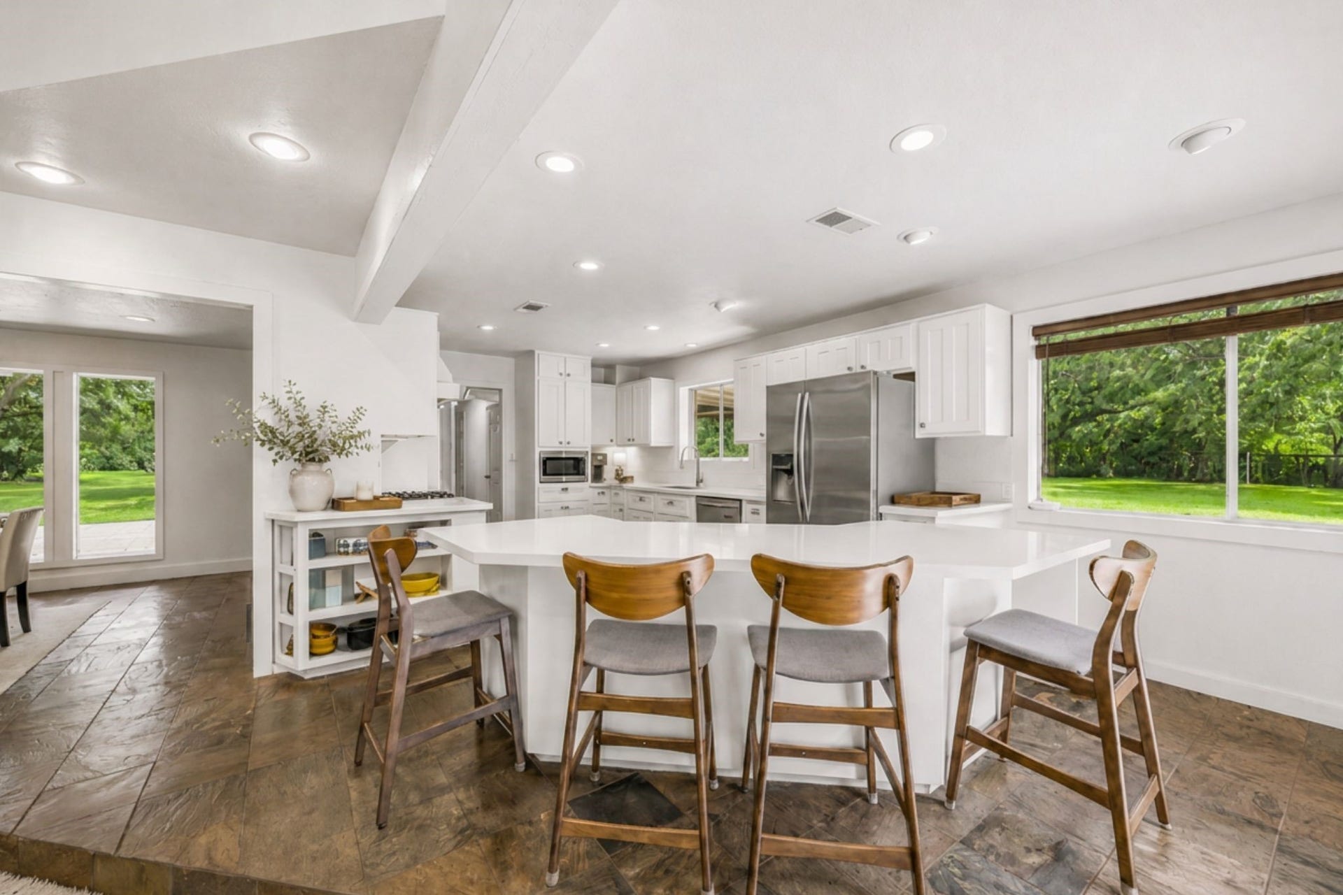 2020 PECAN LAKE DRIVE, Richmond, TX 77406 LARGE KITCHEN OFFERS A GENEROUS BREAKFAST BAR, ABUNDANT CABINET AND COUNTER SPACE, STAINLESS STEEL APPLIANCES, AND LARGE WINDOWS OVERLOOKING THE PROPERTY.