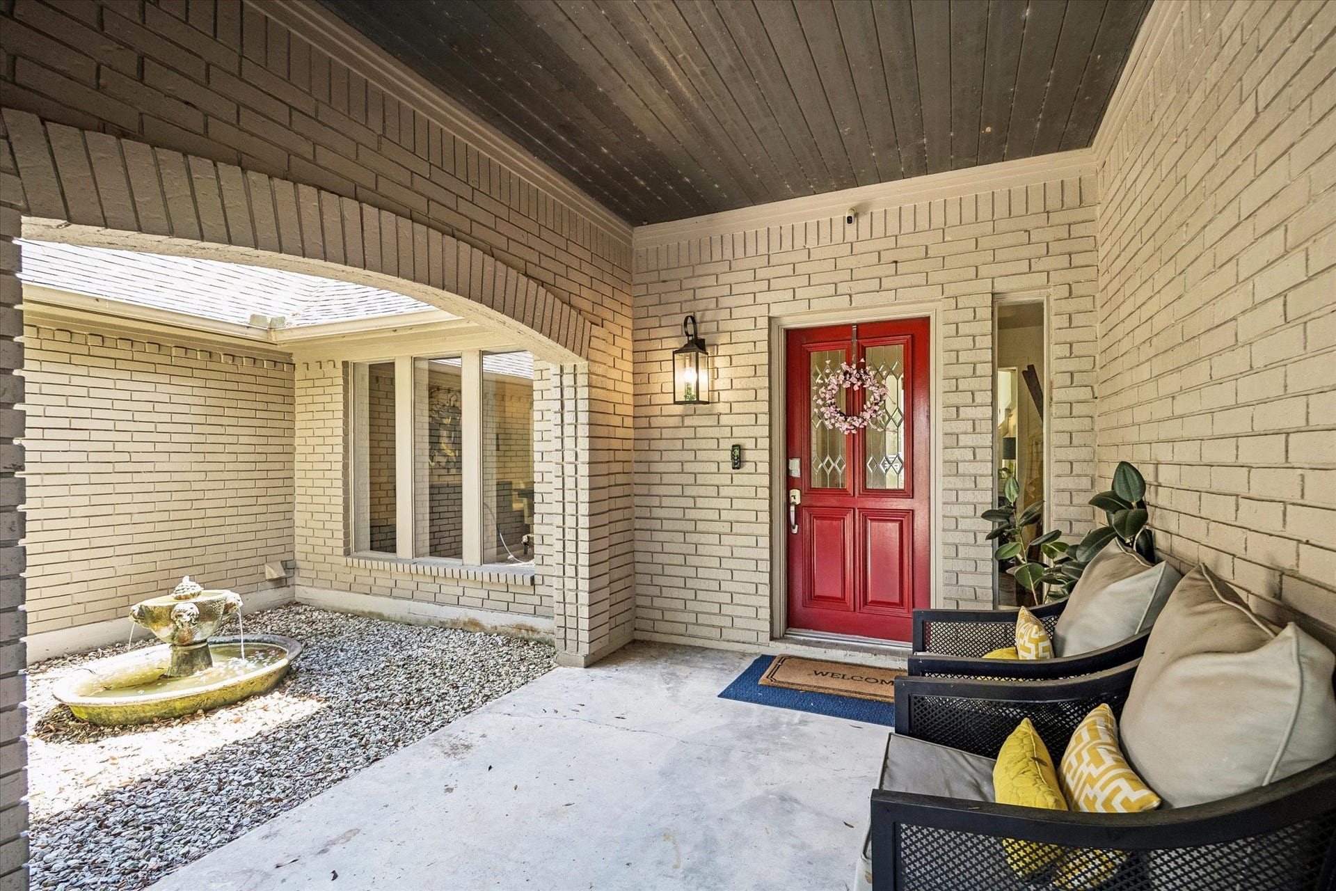2020 PECAN LAKE DRIVE, Richmond, TX 77406 COVERED FRONT ENTRY FEATURES BRICK SURROUND, AN ARCHED OPENING, AND A SHELTERED COURTYARD AREA LEADING TO THE MAIN DOOR.