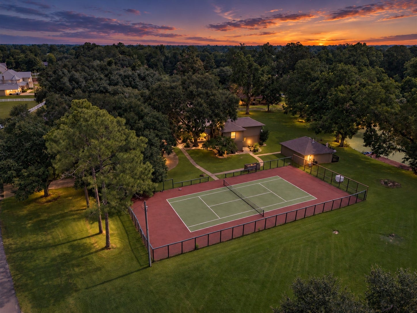 2020 PECAN LAKE DRIVE, Richmond, TX 77406 PRIVATE TENNIS COURT SURROUNDED BY EXPANSIVE LAWN AND MATURE TREES, CREATING A SPACIOUS OUTDOOR RECREATION AREA.