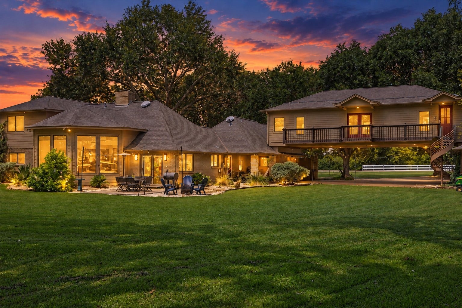 2020 PECAN LAKE DRIVE, Richmond, TX 77406 REAR VIEW HIGHLIGHTS THE HOMES EXPANSIVE FOOTPRINT, LARGE LAWN, PATIO AREA, AND ELEVATED SECOND-STORY SECTION WITH BALCONY ACCESS.