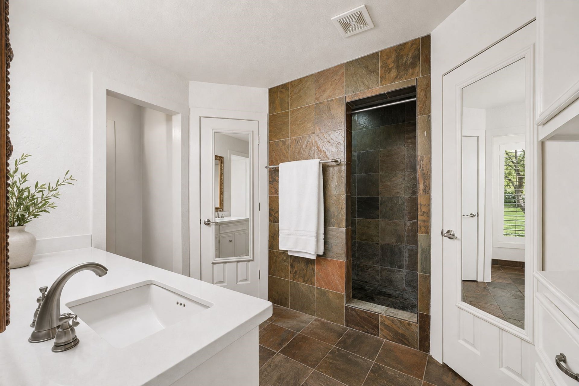 2020 PECAN LAKE DRIVE, Richmond, TX 77406 BATHROOM FEATURES AN EXPANSIVE VANITY, WALK-IN TILED SHOWER, ABUNDANT BUILT-IN STORAGE, AND COORDINATING TILE FLOORING.