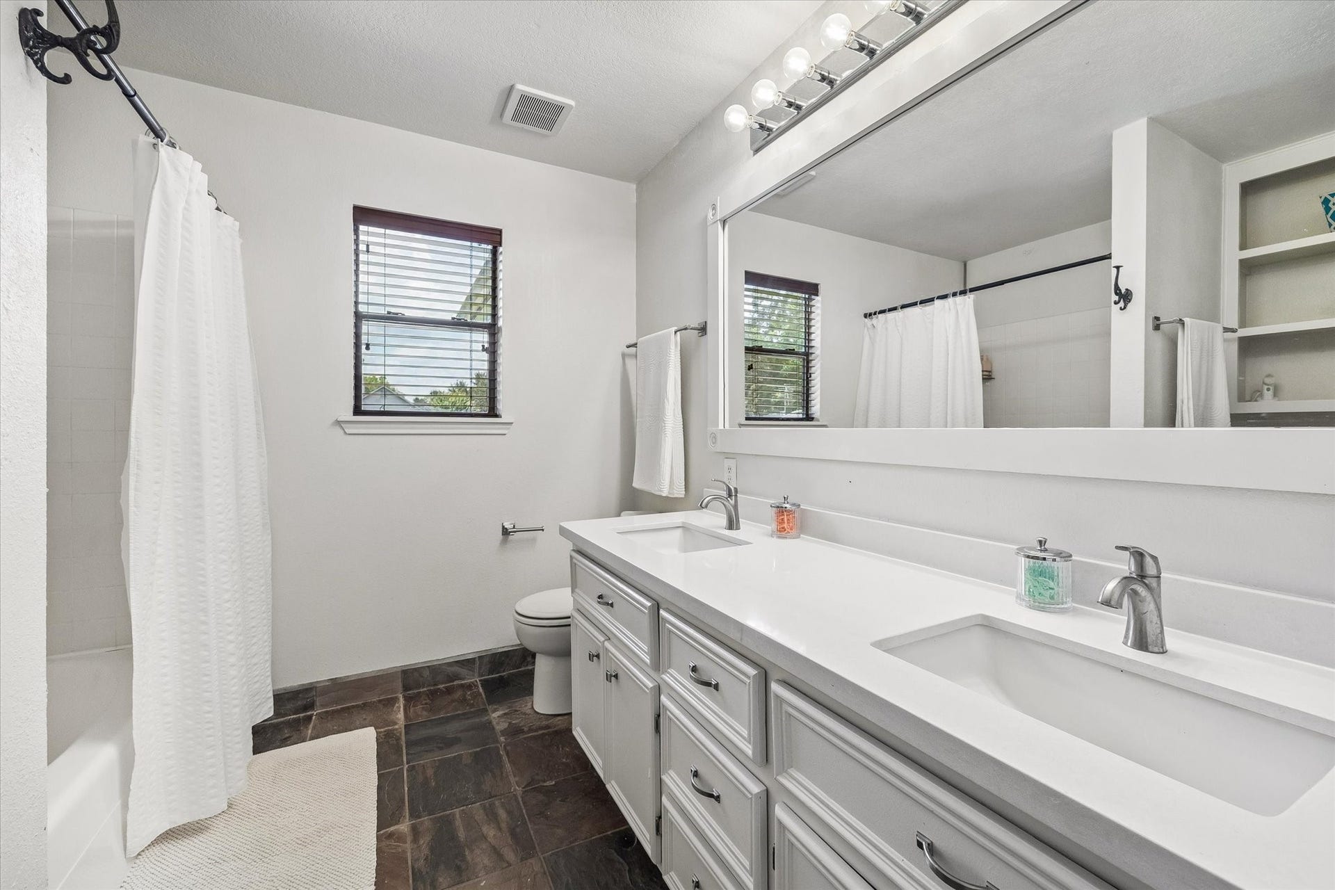 2020 PECAN LAKE DRIVE, Richmond, TX 77406 SECONDARY BATHROOM FEATURES A LONG DUAL-SINK VANITY, OVERSIZED MIRROR, TUB/SHOWER COMBINATION, AND TILE FLOORING.