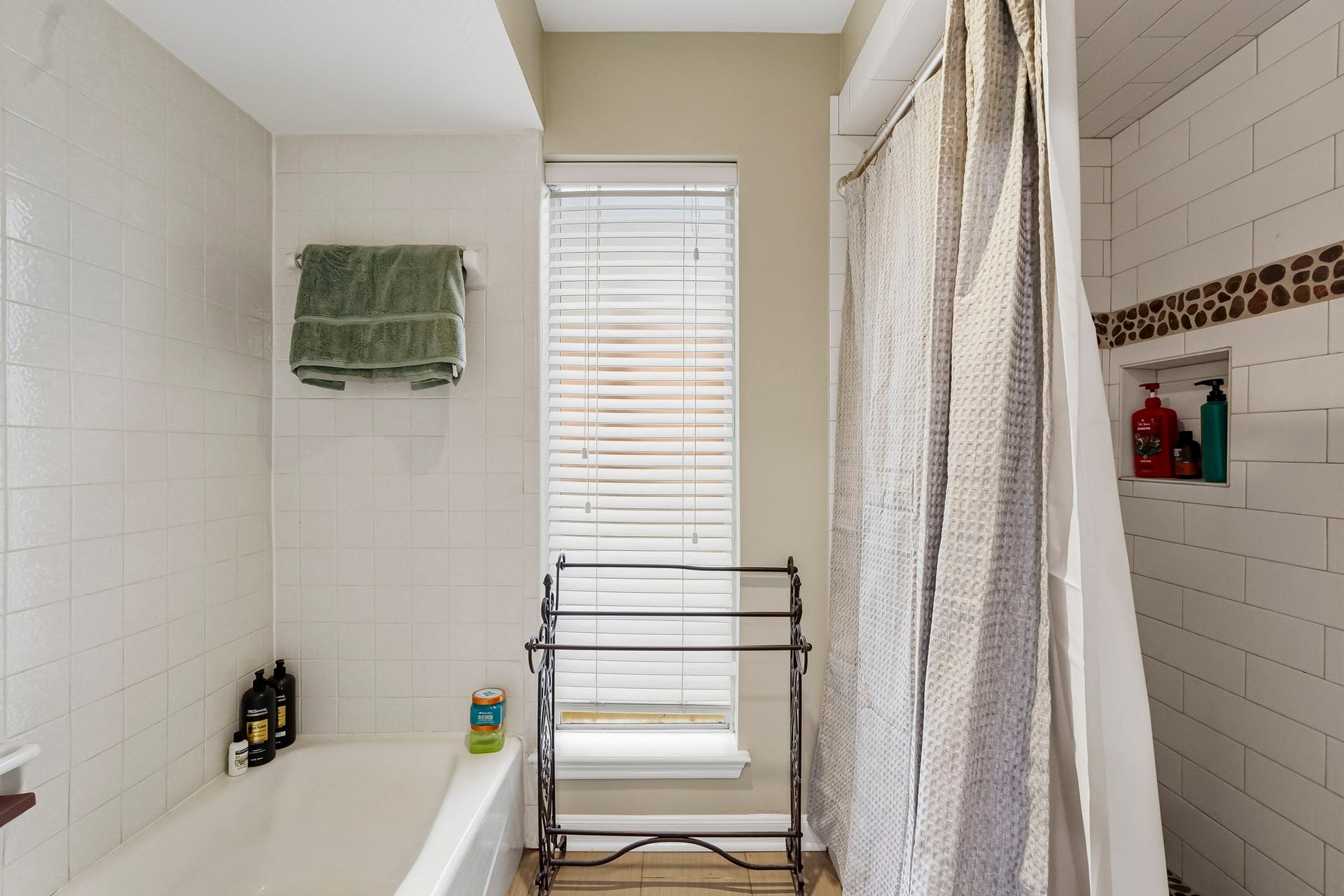 3610 Valley Haven Drive, Houston, TX 77339 Bright bathroom with a cozy tub and shower combo, featuring stylish tile accents and ample natural light through large windows.