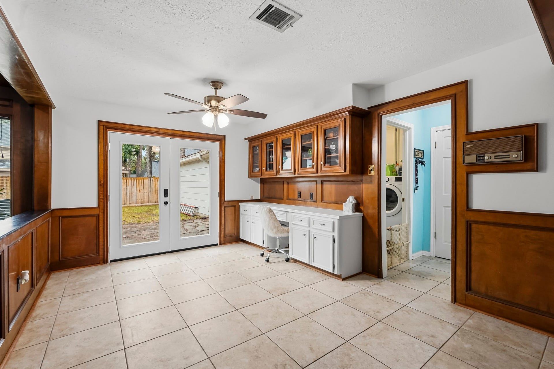 3610 Valley Haven Drive, Houston, TX 77339 Breakfast nook area with elegant wood paneling, built-in cabinetry, and natural light from French doors leading to a fenced backyard.