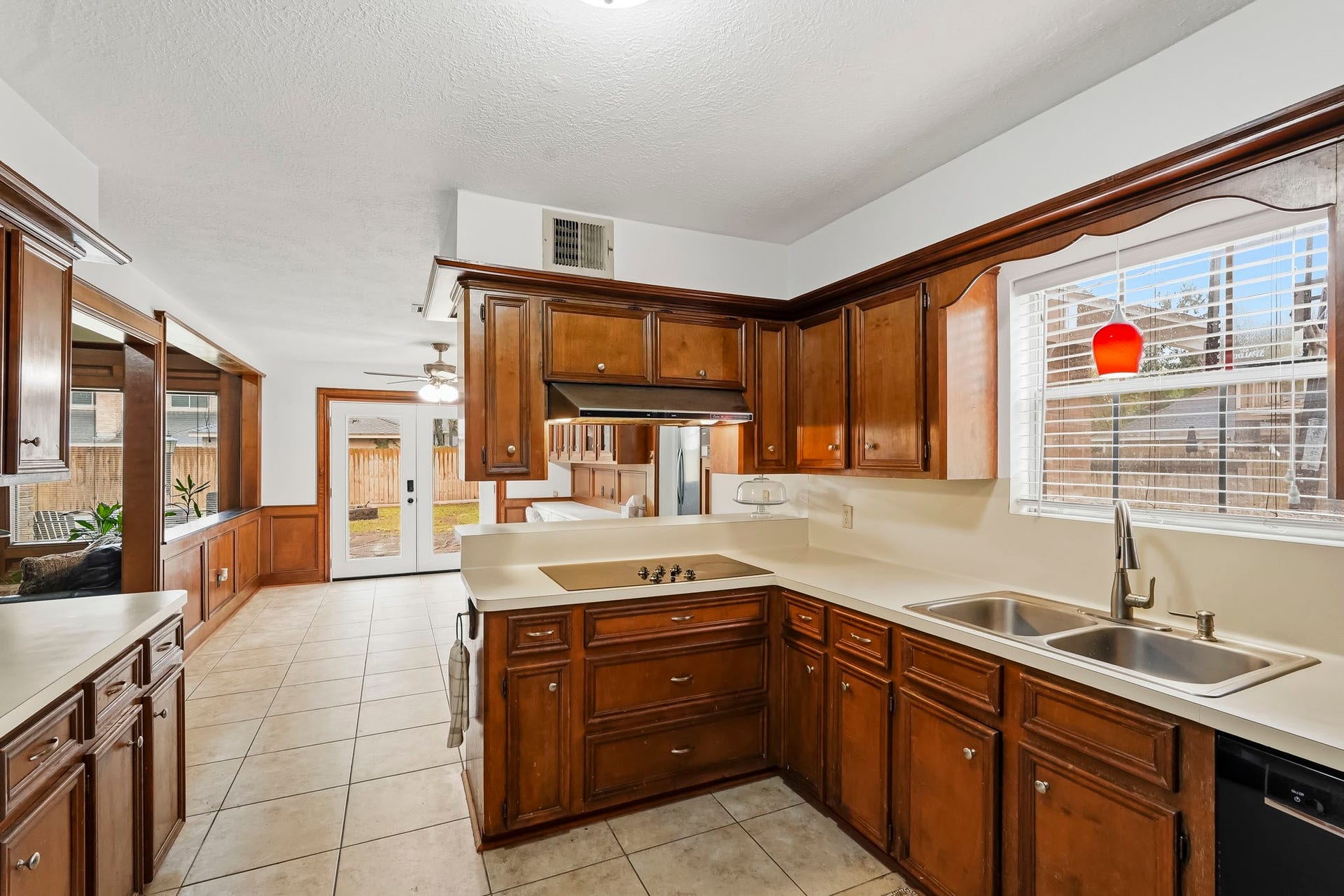 3610 Valley Haven Drive, Houston, TX 77339 Charming kitchen with rich wood cabinetry, tile flooring, and ample natural light, seamlessly leading to a cozy breakfast nook area with a view of the backyard.