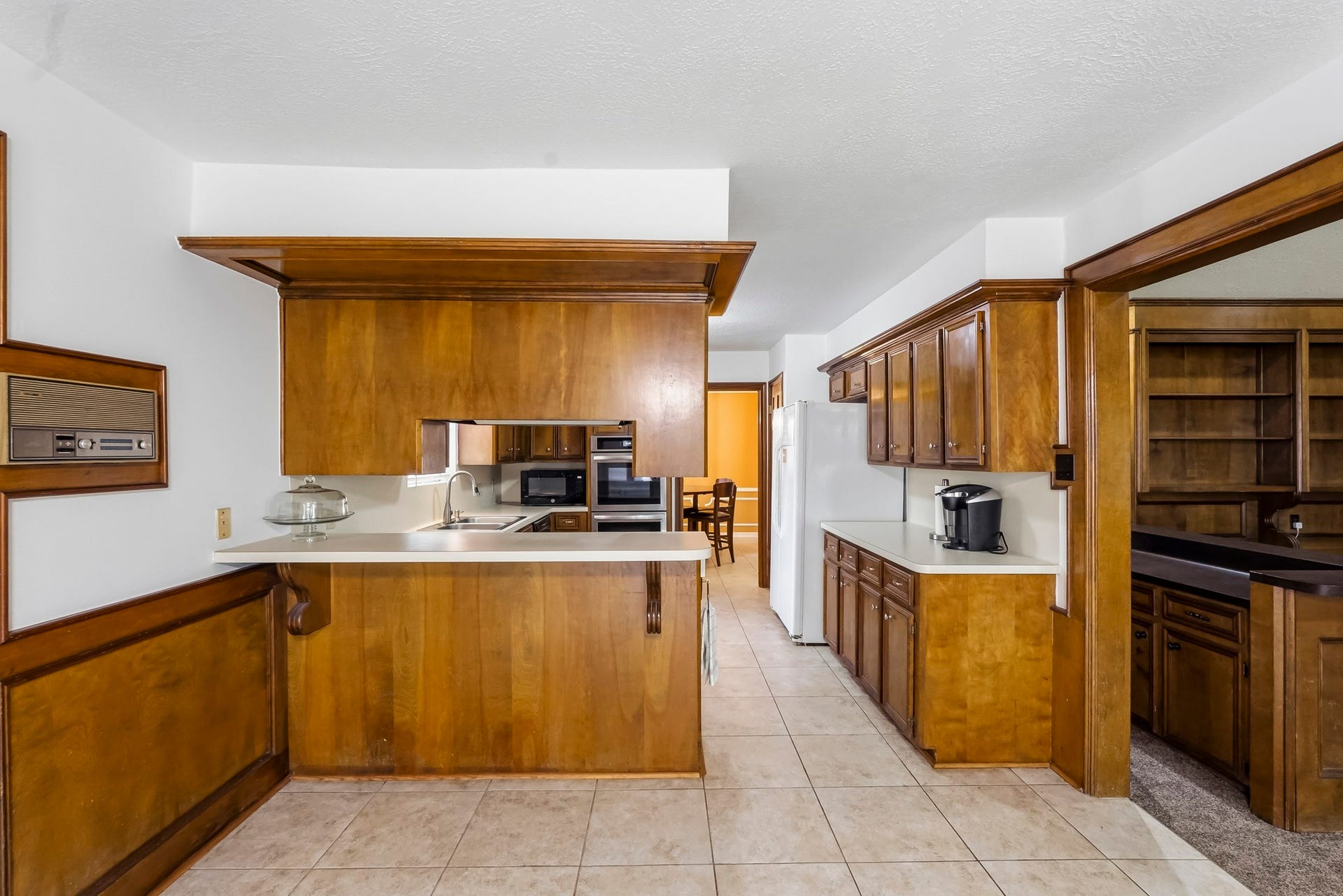 3610 Valley Haven Drive, Houston, TX 77339 Charming kitchen with rich wood cabinetry, ample counter space, and a cozy breakfast bar, seamlessly connecting to a well-lit dining area.