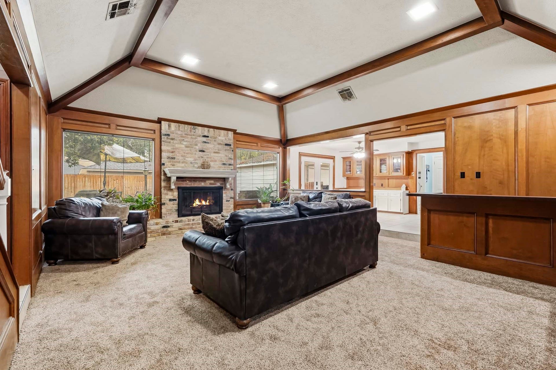 3610 Valley Haven Drive, Houston, TX 77339 Spacious living room with vaulted ceilings, featuring a cozy brick fireplace and large windows that invite natural light.
