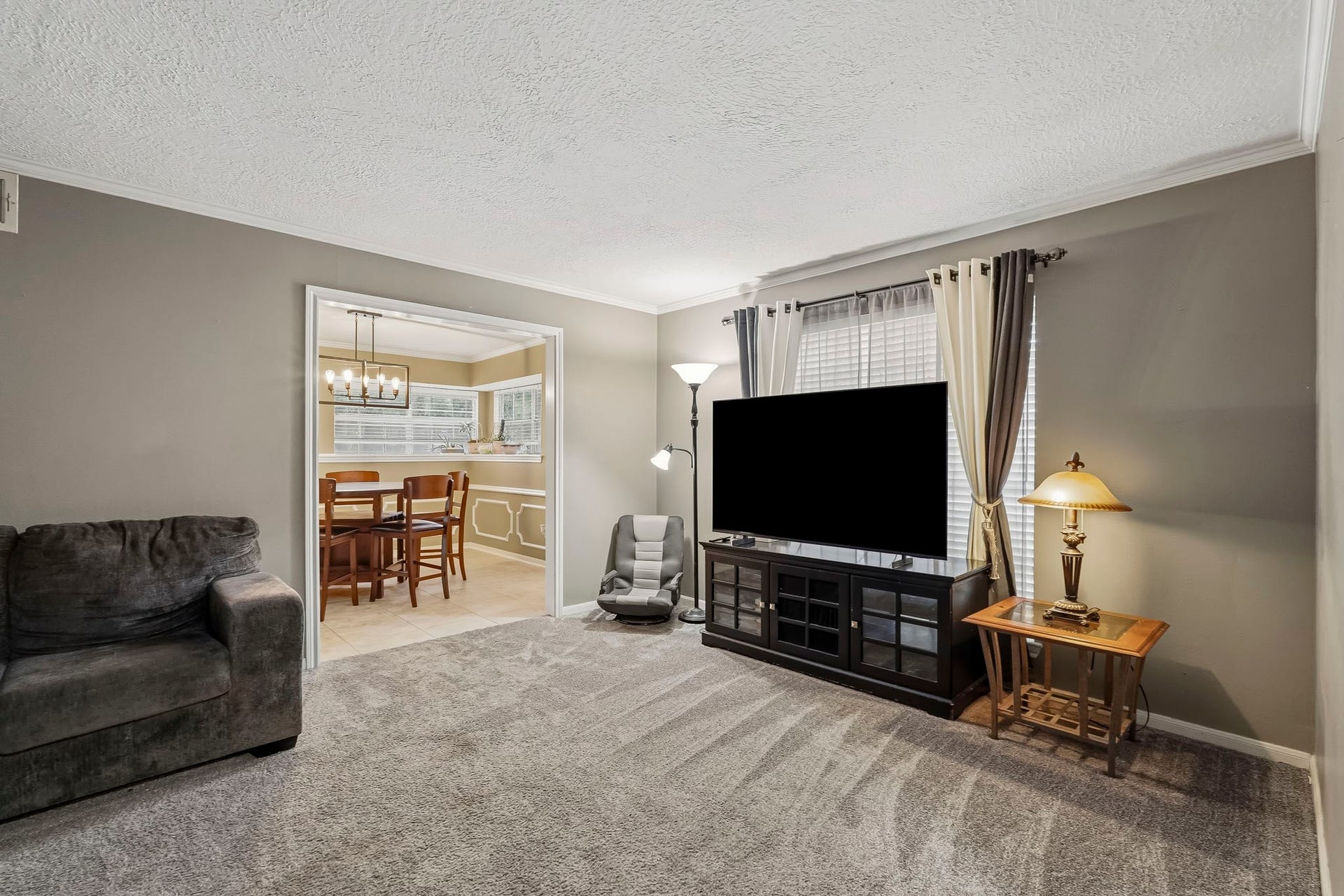 3610 Valley Haven Drive, Houston, TX 77339 Cozy flex room or formal living with plush carpeting and a large window for natural light, seamlessly connected to a dining area with elegant lighting.