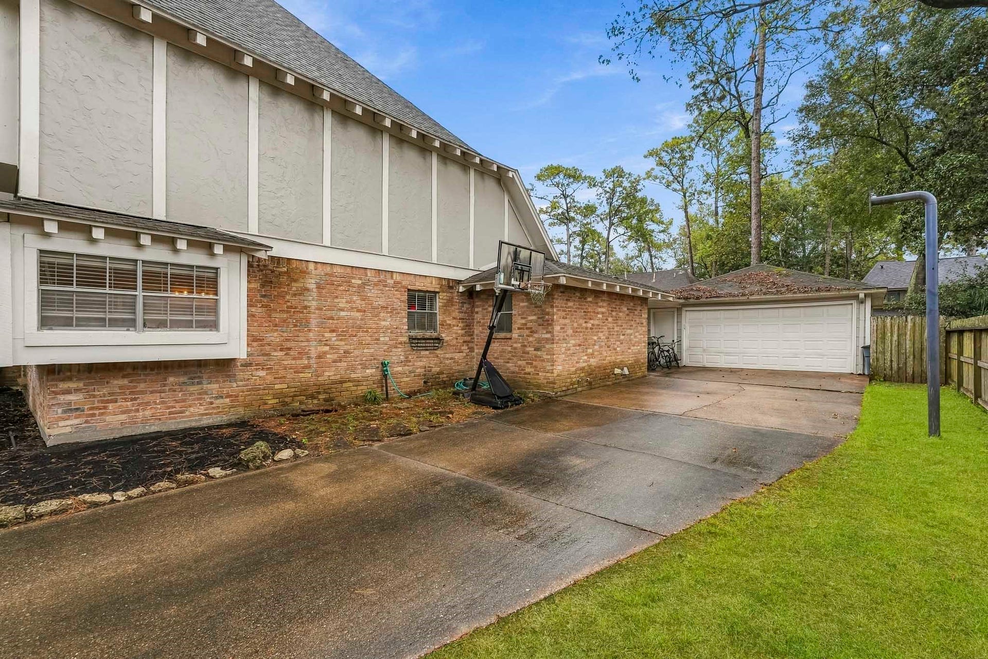 3610 Valley Haven Drive, Houston, TX 77339 Charming home with a spacious driveway leading to a two-car garage, surrounded by mature trees and a well-maintained lawn.