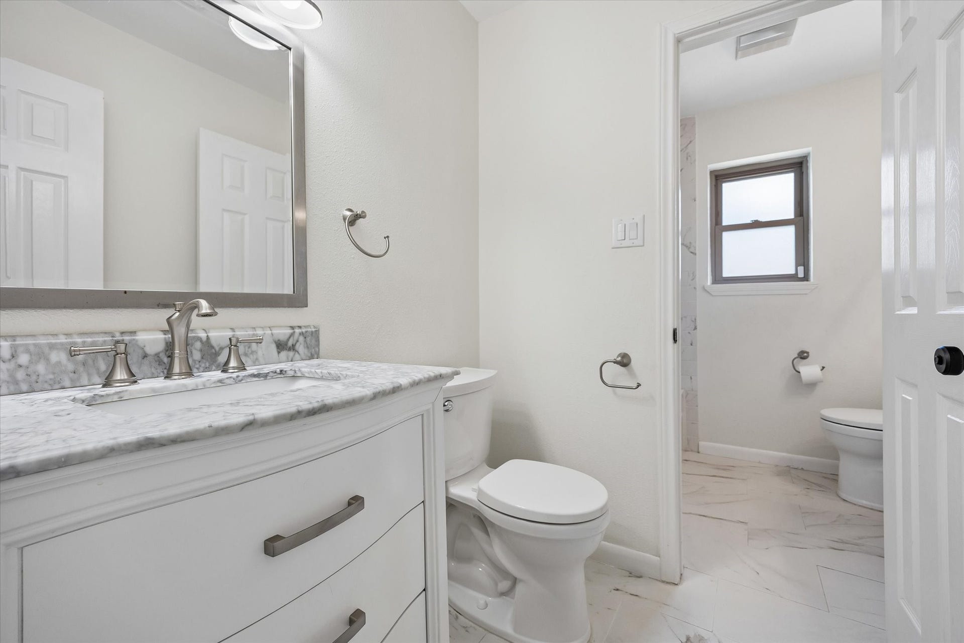 10831 Olympia Drive, Houston, TX 77042 Beautifully updated guest bath offers separate sink areas and tub/shower combo with subway tile surround.