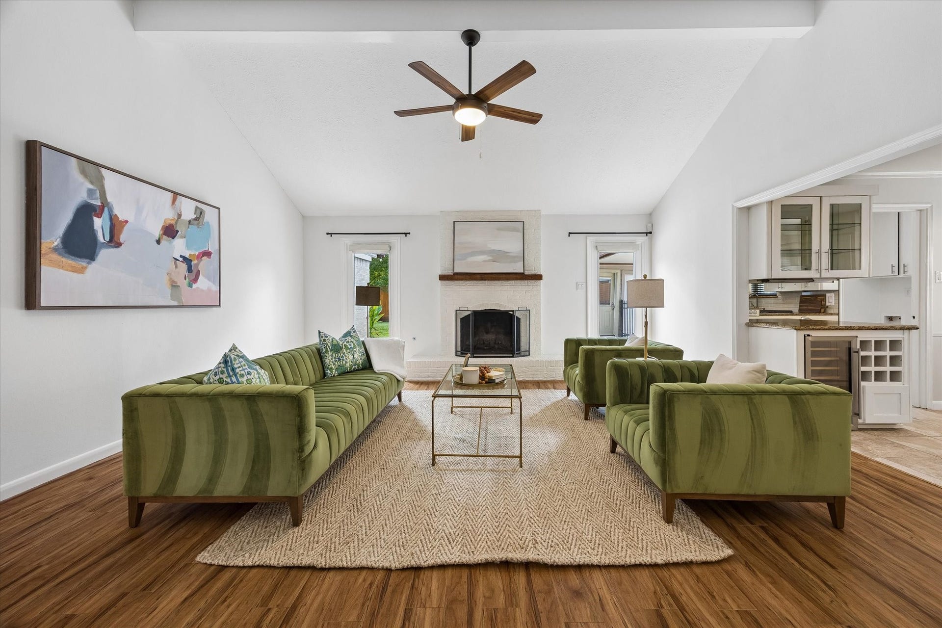 10831 Olympia Drive, Houston, TX 77042 Soaring vaulted ceilings and a classic brick fireplace highlight the main living space, where custom-shaded windows invite in abundant natural light.