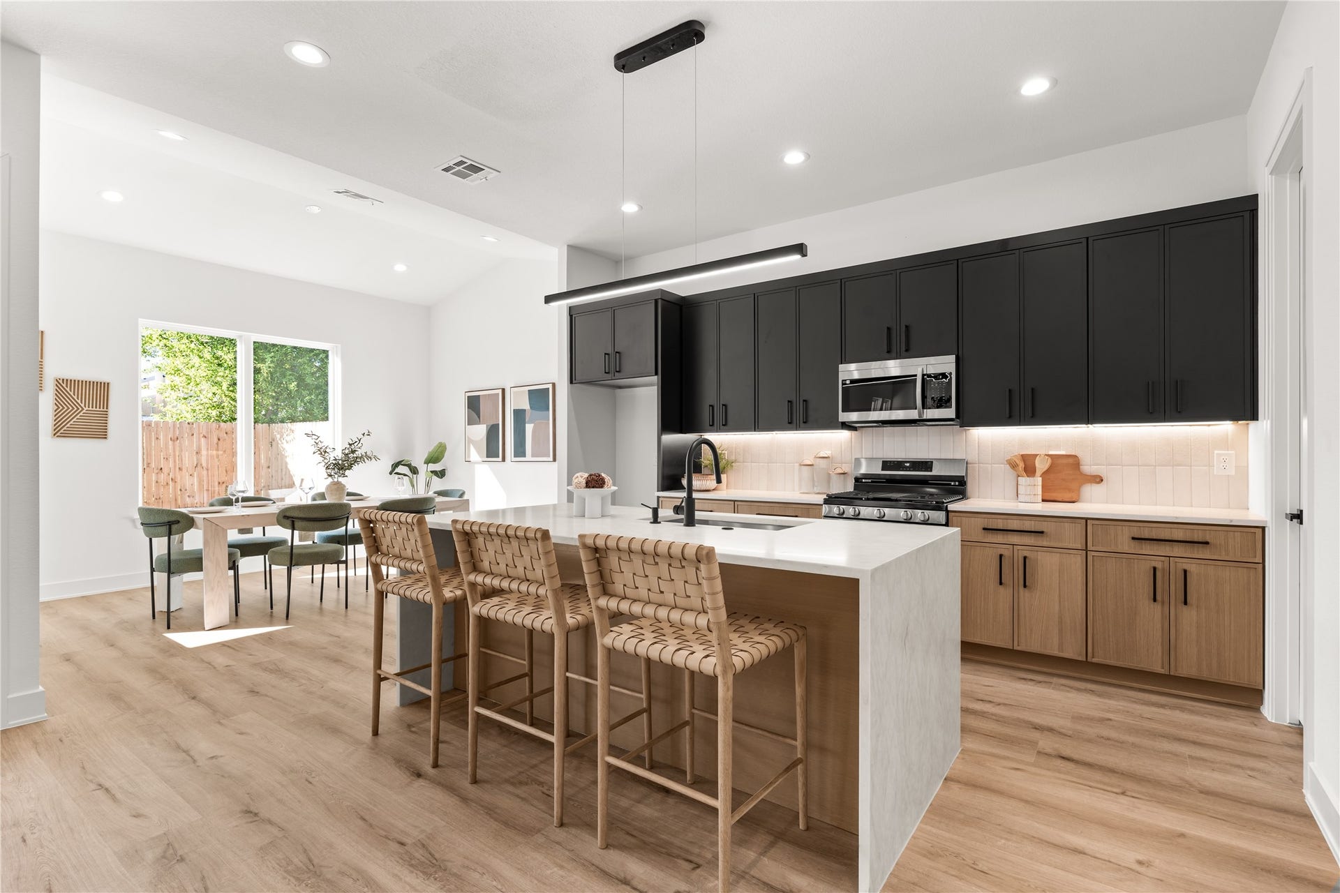 6714 Tierwester Street, Houston, TX 77021 Nima Homes' attention to detail is reflected in the kitchen's layered material palette, from vertically stacked backsplash tile and illuminated countertops to sleek black hardware and contrasting cabinetry.