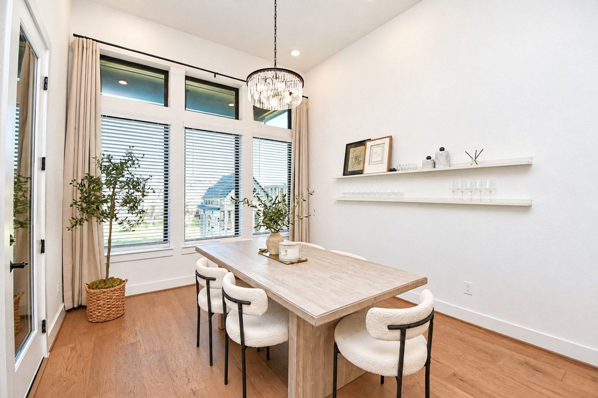 20222 Palomar Pointe Drive, Cypress, TX 77433 Elegant dining area with large windows for natural light, featuring a modern chandelier and built-in shelving.