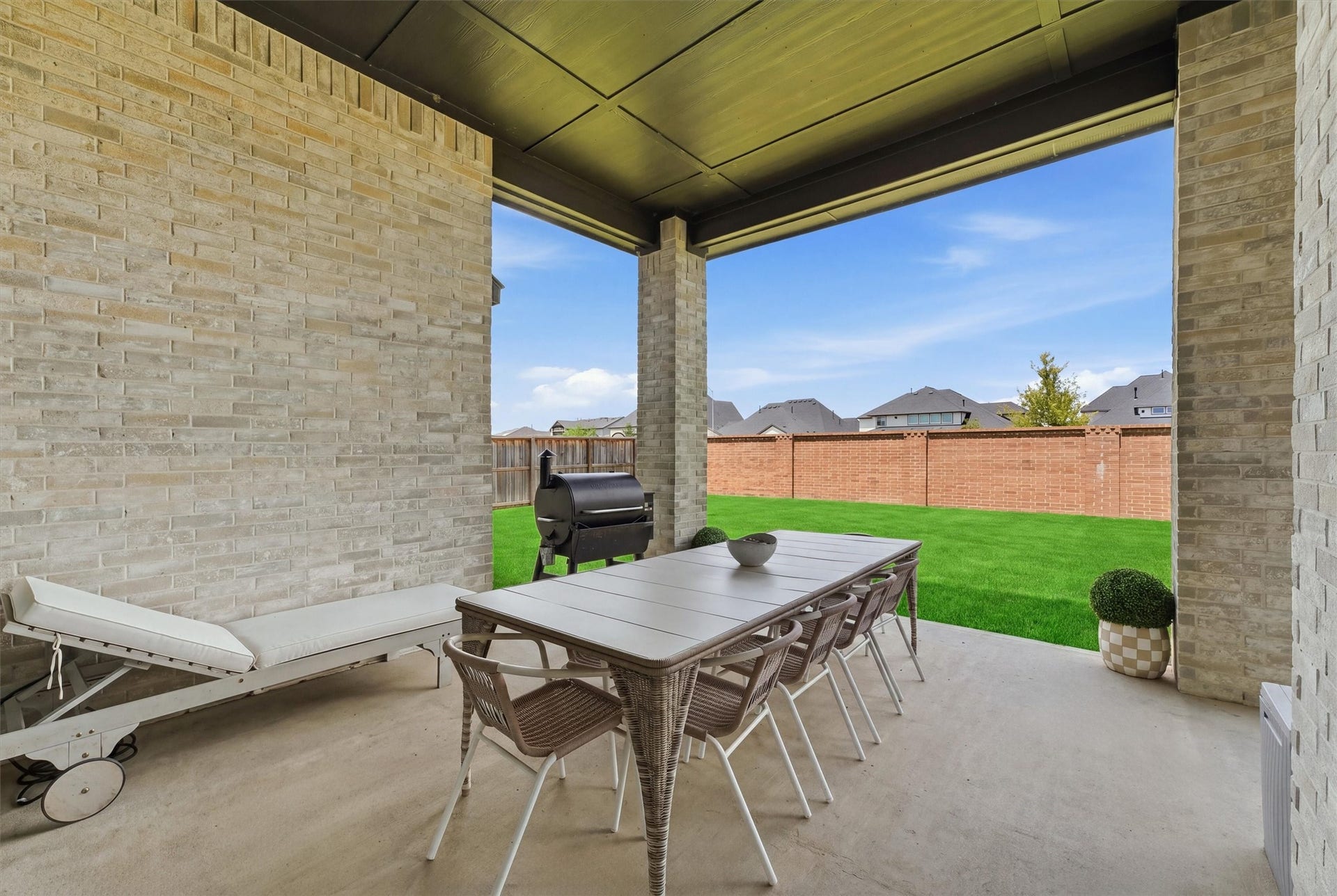 20222 Palomar Pointe Drive, Cypress, TX 77433 Spacious covered outdoor patio overlooking a beautifully maintained backyard, offering plenty of room for dining, lounging, grilling, and entertaining. The brick privacy wall and generous green space create a private, relaxing setting perfect for enjoying the outdoors year round.