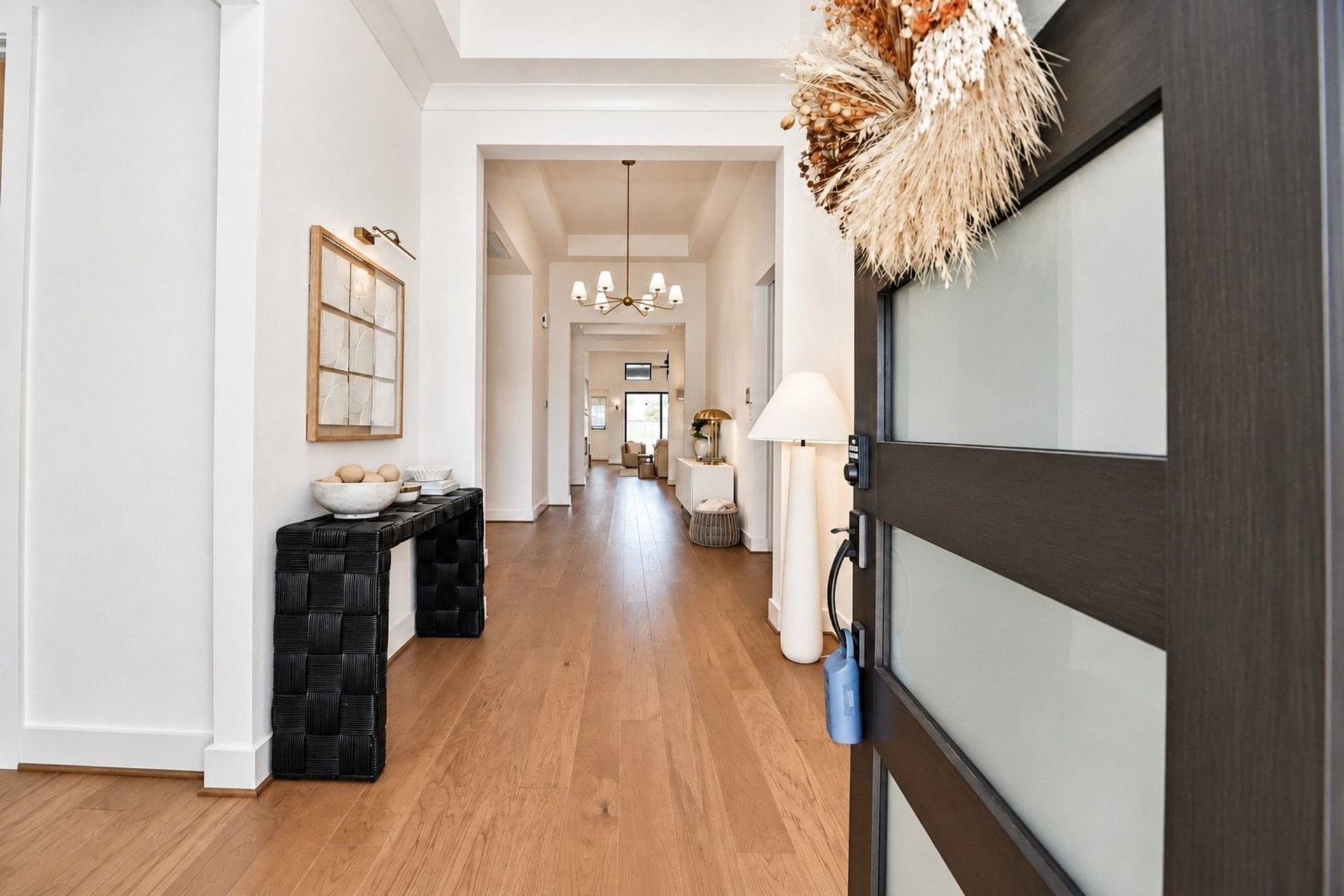 20222 Palomar Pointe Drive, Cypress, TX 77433 Step into a bright and welcoming entryway with elegant wood flooring, modern decor, and a stylish light fixture leading to an open and inviting living space.