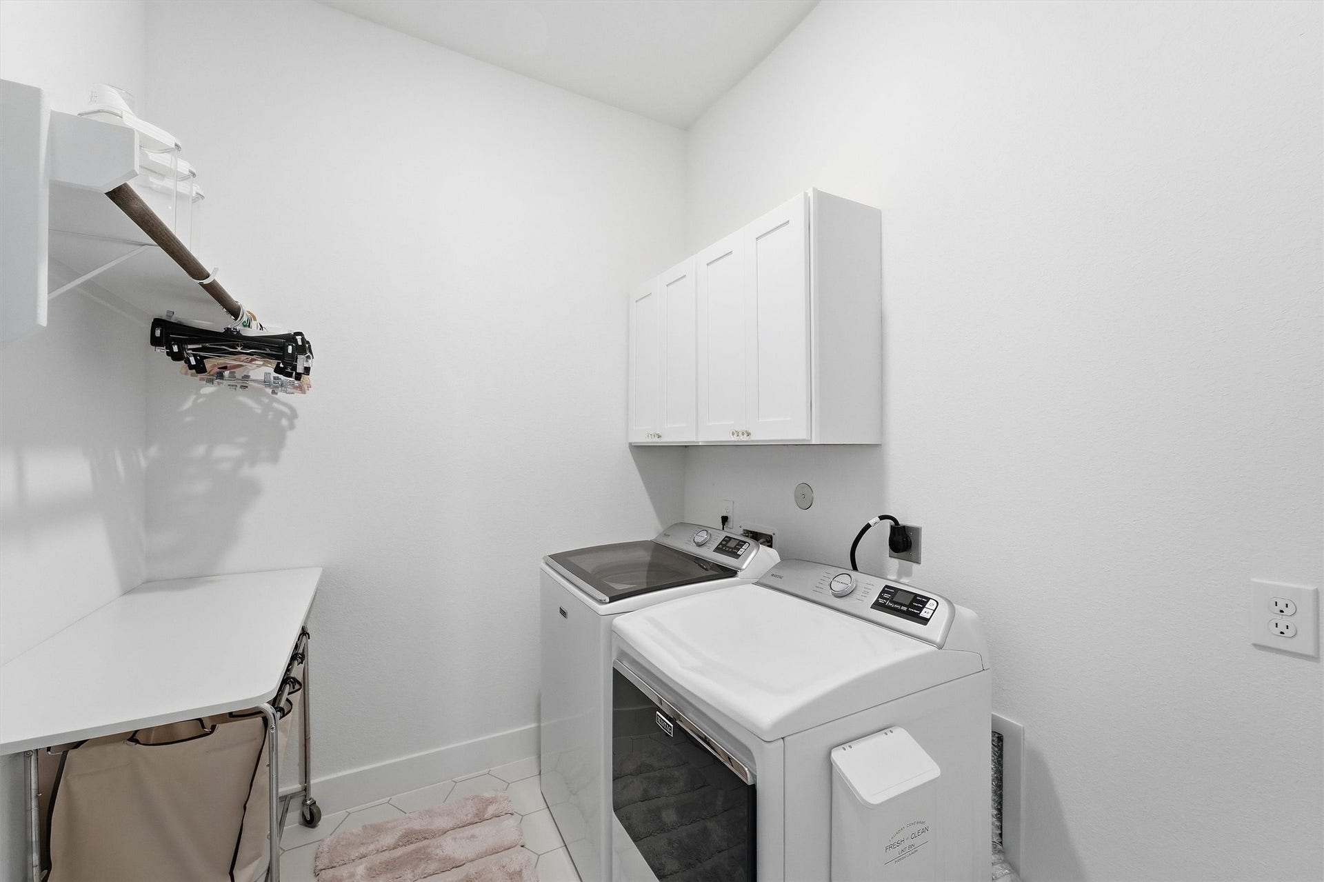 20222 Palomar Pointe Drive, Cypress, TX 77433 Built-in cabinetry provides convenient storage for laundry supplies and household essentials. A dedicated folding bar offers valuable workspace for sorting and folding.
