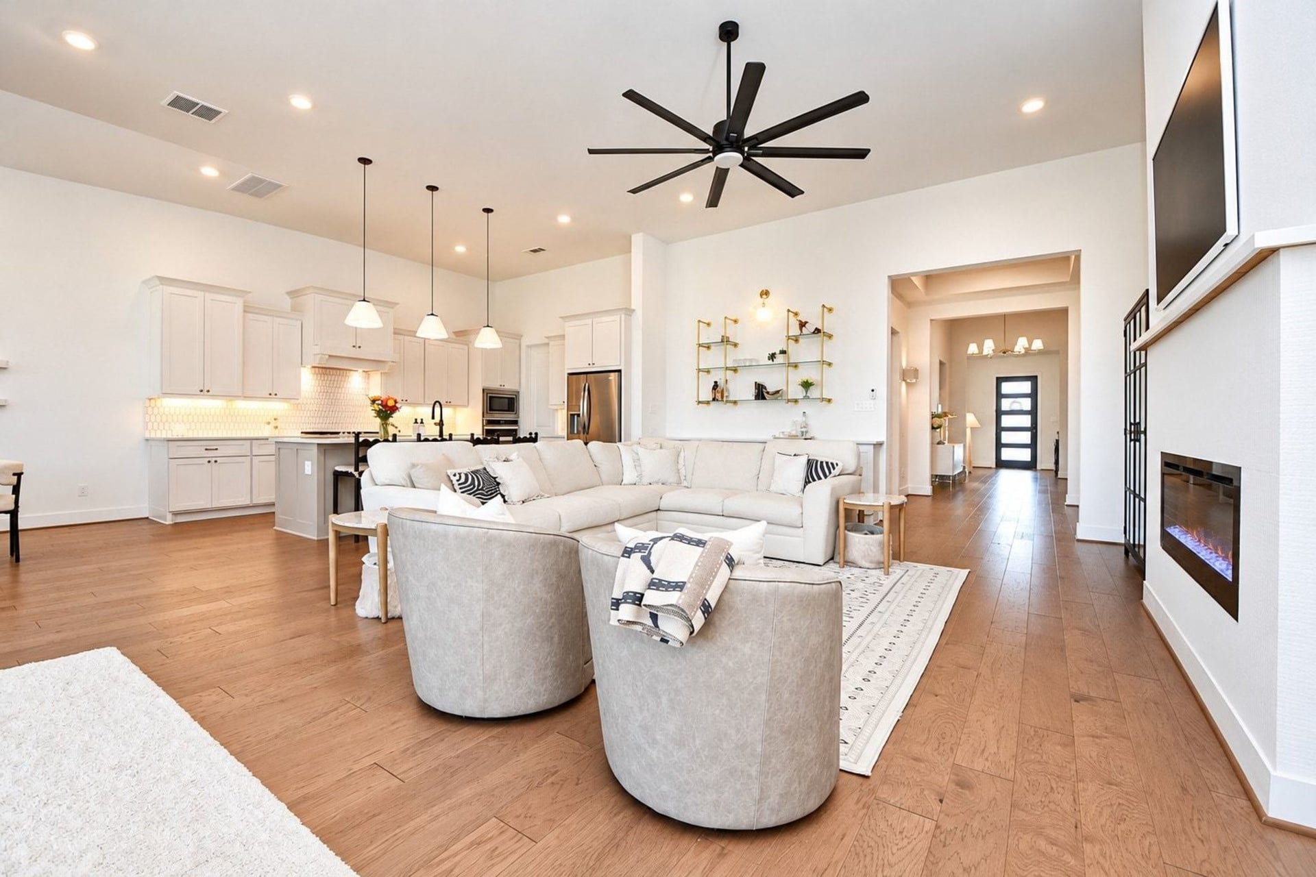 20222 Palomar Pointe Drive, Cypress, TX 77433 Spacious open-concept living area with modern kitchen, elegant light fixtures, and a cozy fireplace, perfect for entertaining.