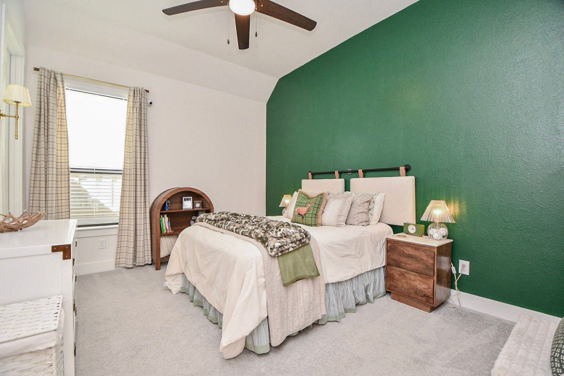 20222 Palomar Pointe Drive, Cypress, TX 77433 Cozy bedroom with a striking green accent wall, plush carpeting, and a ceiling fan. Natural light filters through the window, complementing the warm, inviting decor.