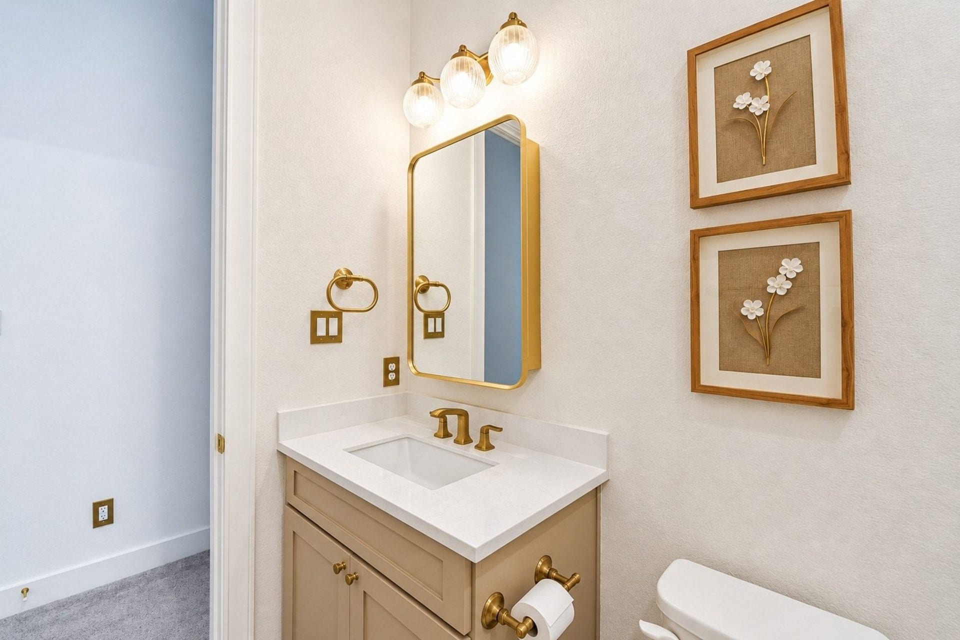 20222 Palomar Pointe Drive, Cypress, TX 77433 Chic bathroom with elegant gold fixtures, a sleek vanity with upgraded lighting, and tasteful floral artwork, offering a sophisticated and inviting atmosphere.