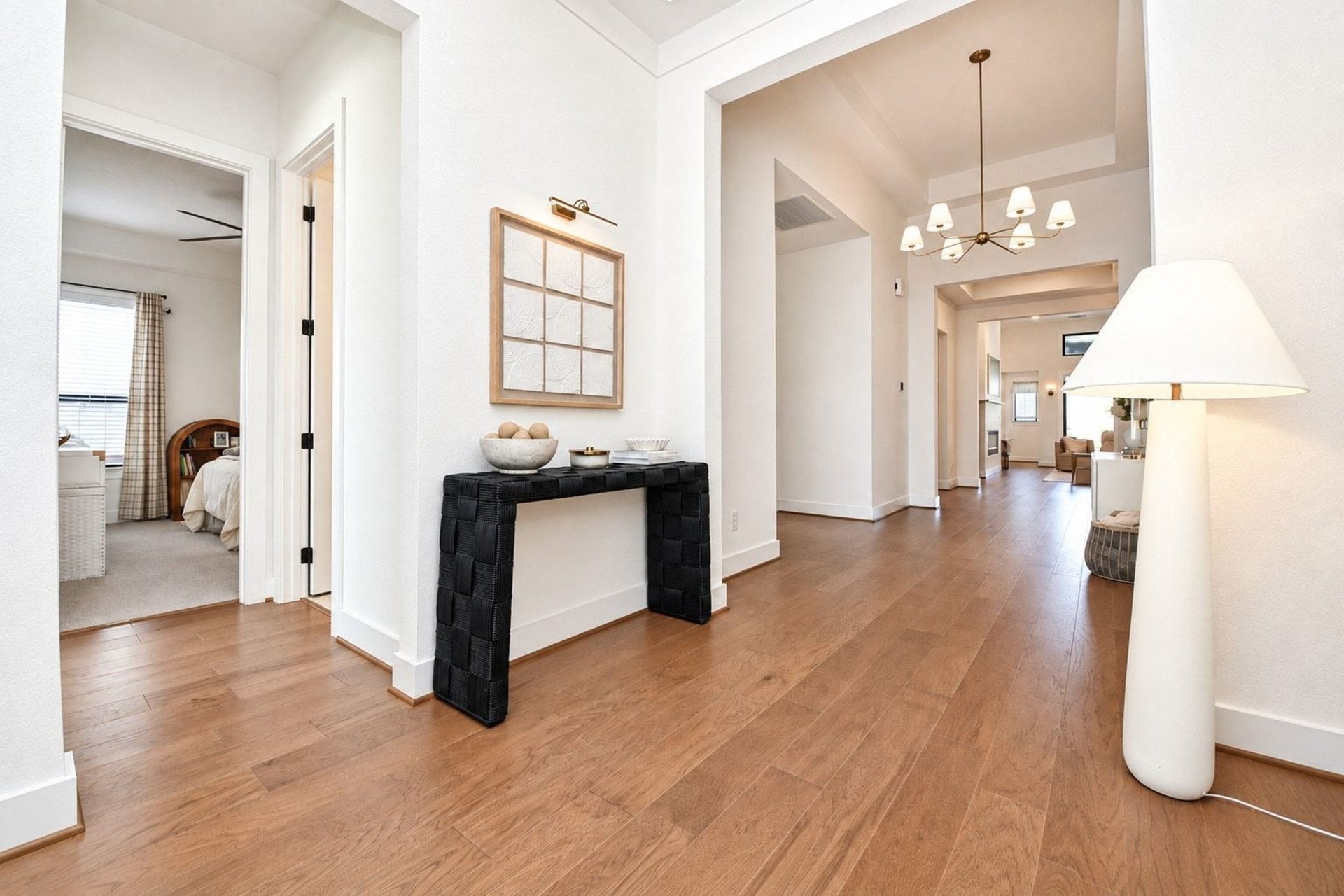 20222 Palomar Pointe Drive, Cypress, TX 77433 Inviting entryway with warm wooden floors and modern lighting, leading to a spacious, light-filled living area.