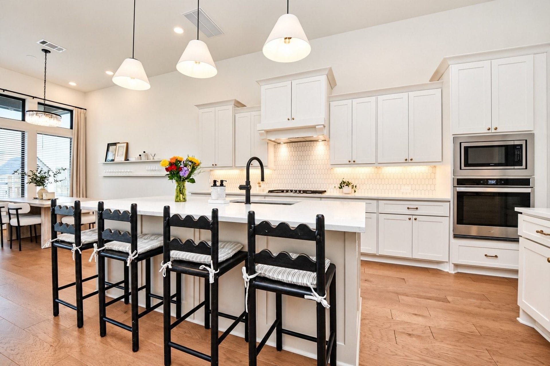 20222 Palomar Pointe Drive, Cypress, TX 77433 Bright and spacious kitchen featuring sleek white cabinetry, stainless steel appliances, upgraded pendent lights that cover a large island with seating, perfect for entertaining.