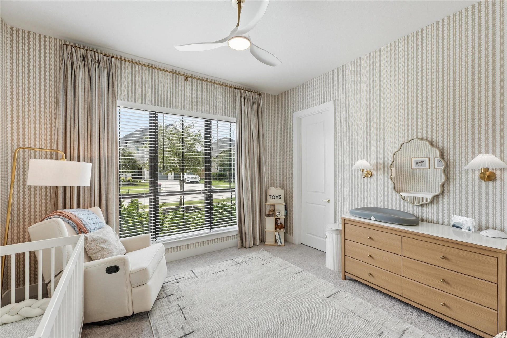 20222 Palomar Pointe Drive, Cypress, TX 77433 A delightful secondary bedroom or nursery bathed in natural light, featuring soft patterned wallpaper, elegant window treatments, modern lighting, and plush carpeting, creating a warm and inviting space full of charm.