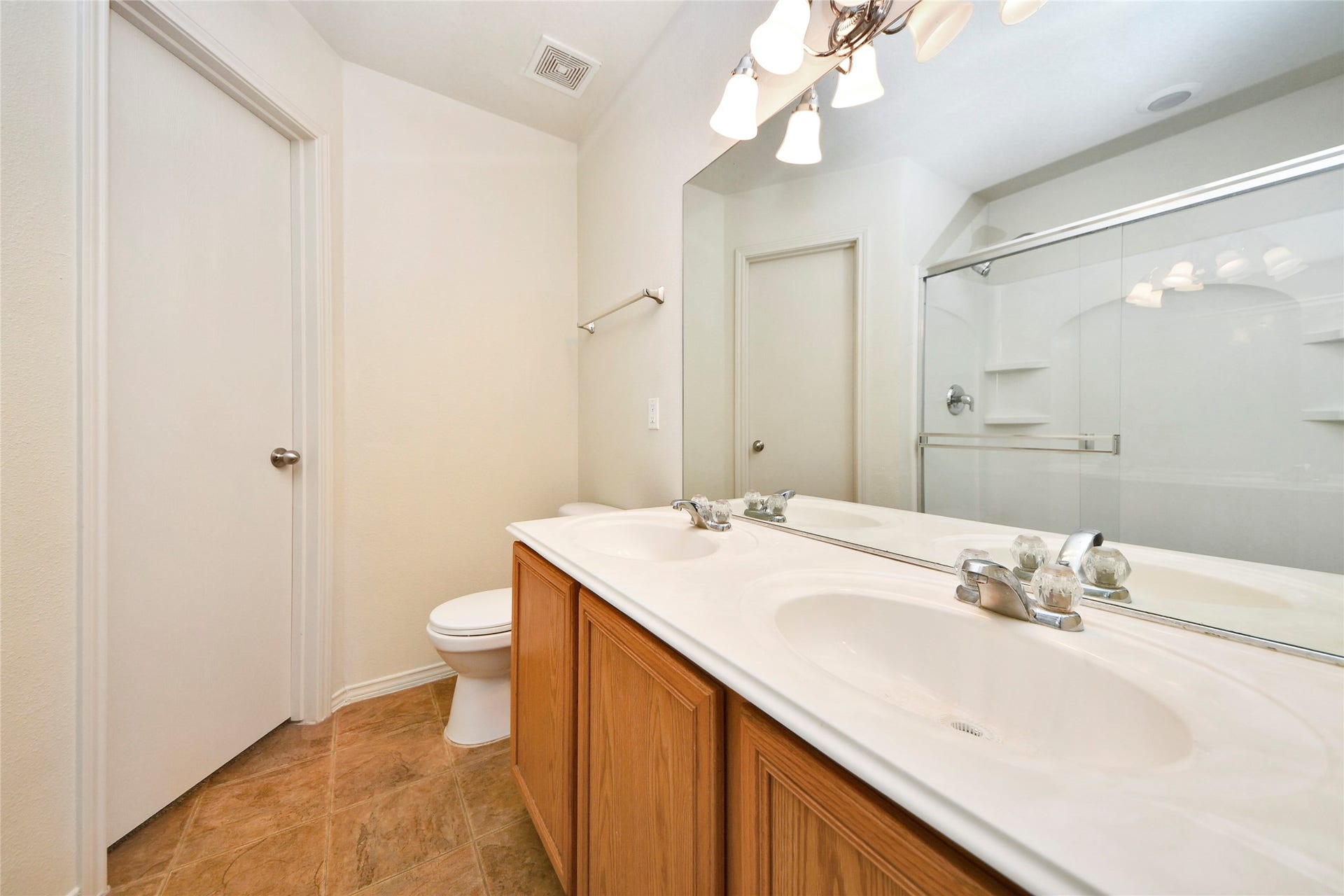 Experience the elegance of this spacious second-floor primary bathroom, featuring a sleek double vanity and a modern glass-enclosed shower.