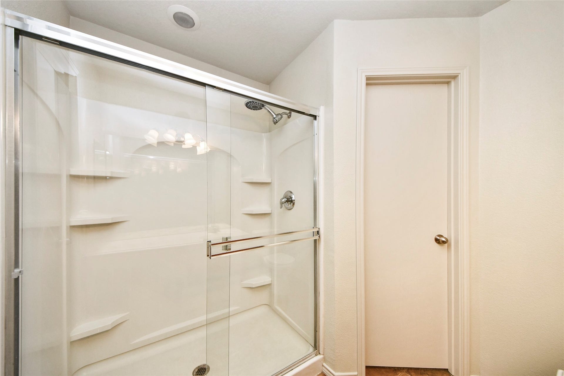 Experience the elegance of a bright primary bathroom featuring a sleek glass-enclosed shower, perfect for a refreshing start to your day.