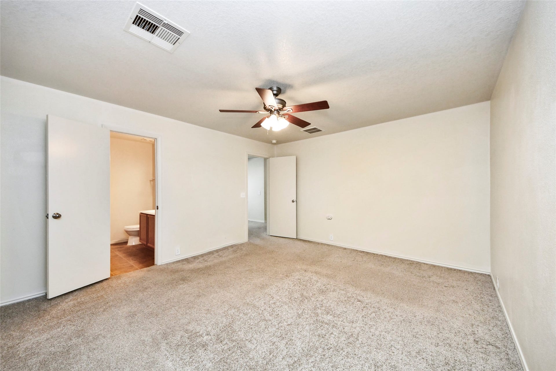 Spacious and inviting, the primary bedroom on the second floor features plush carpeting, a cozy ceiling fan, and convenient en-suite access, creating the perfect retreat.