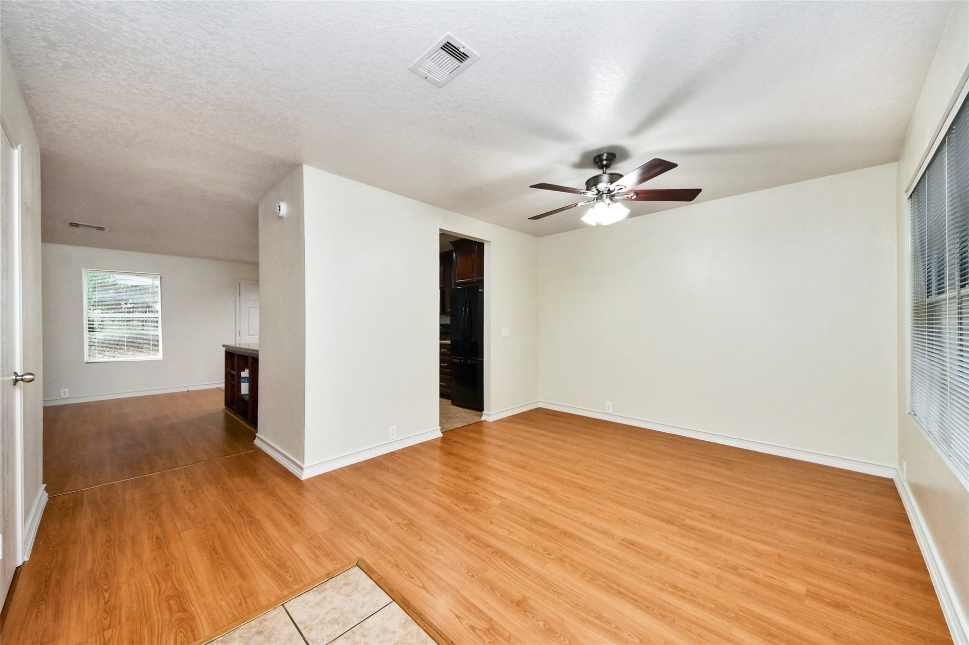 Experience the warmth and versatility of this inviting den, featuring sleek wood floors and abundant natural light, perfect for relaxation or entertaining.
