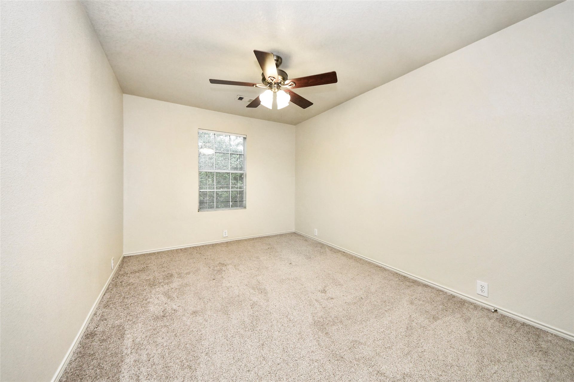 Spacious and inviting, the third bedroom features plush carpeting, a ceiling fan, and abundant natural light, offering a perfect retreat or versatile space for your lifestyle needs.