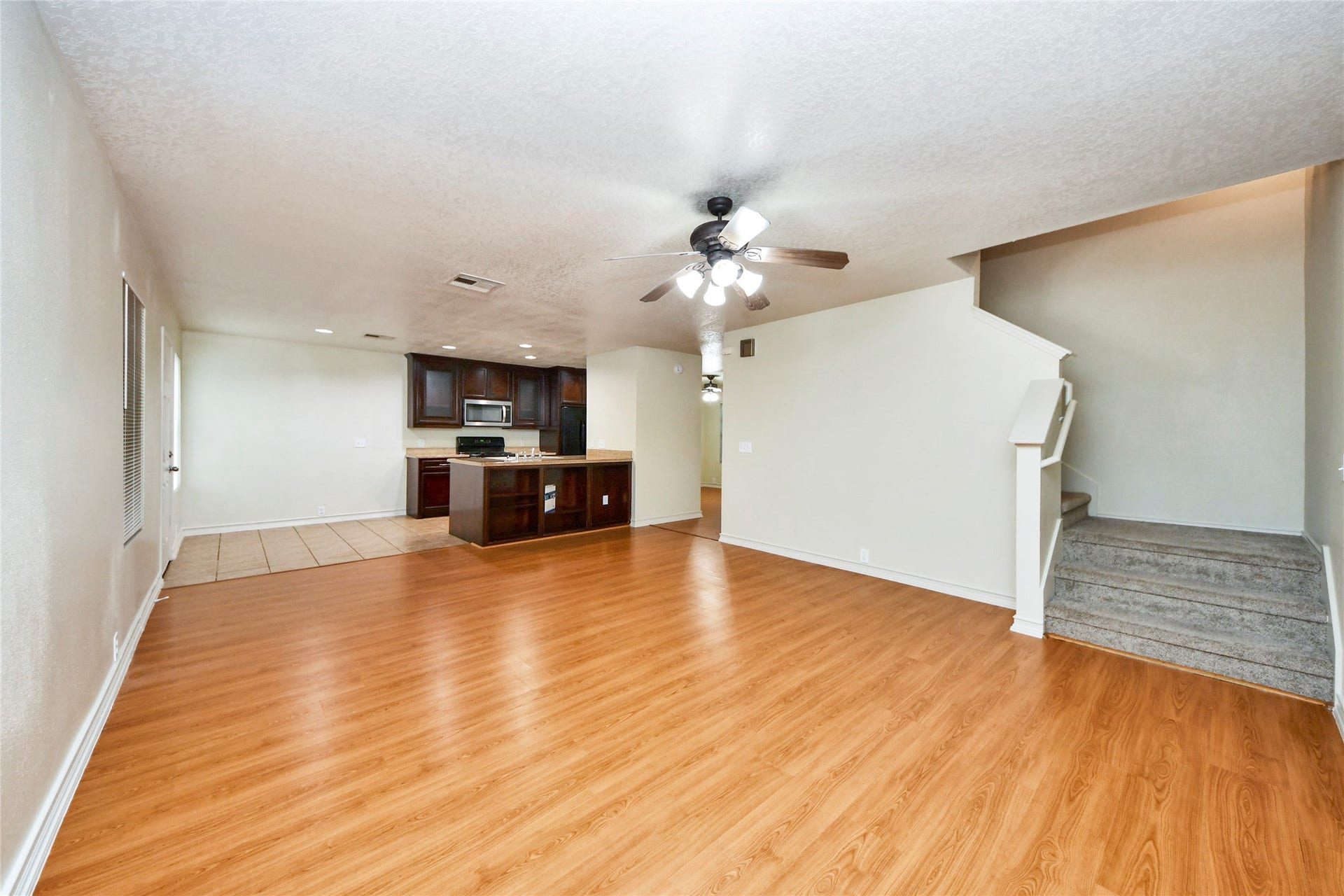 Spacious and inviting, this family room seamlessly flows into a modern kitchen, perfect for both entertaining and everyday living.