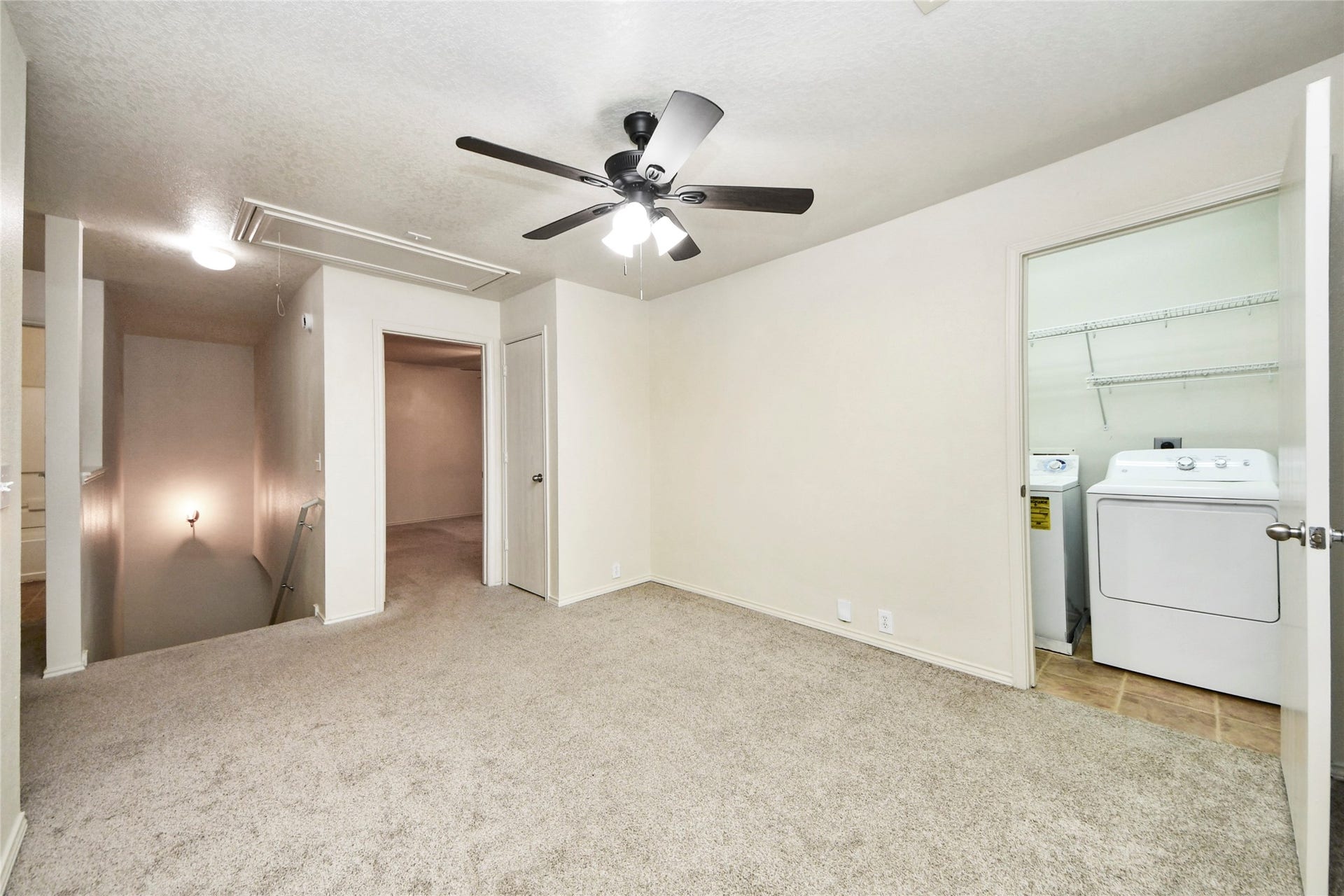 Elevate your entertainment in this versatile game room, complete with plush carpeting and convenient access to a laundry area.
