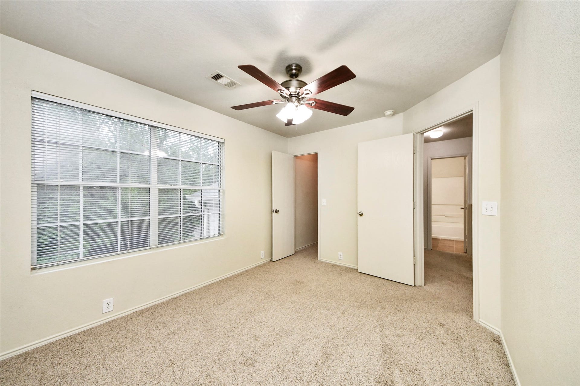Bright and inviting, the second bedroom offers ample natural light and cozy carpeting, creating a perfect retreat for relaxation or productivity.