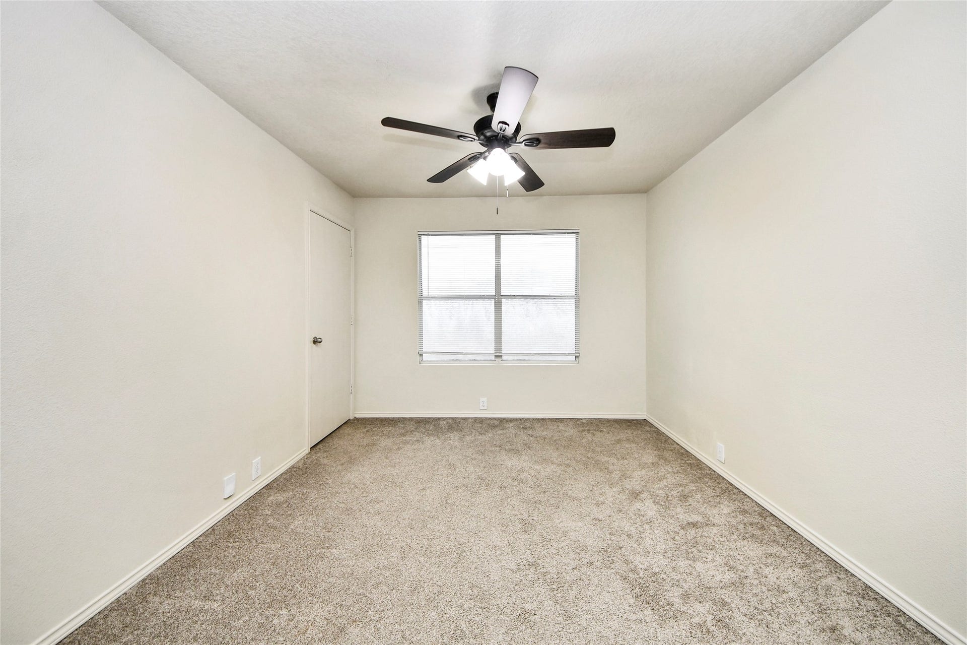 Bright and inviting, the third bedroom offers ample space and comfort with its plush carpeting and modern ceiling fan, perfect for relaxation or a cozy guest retreat.