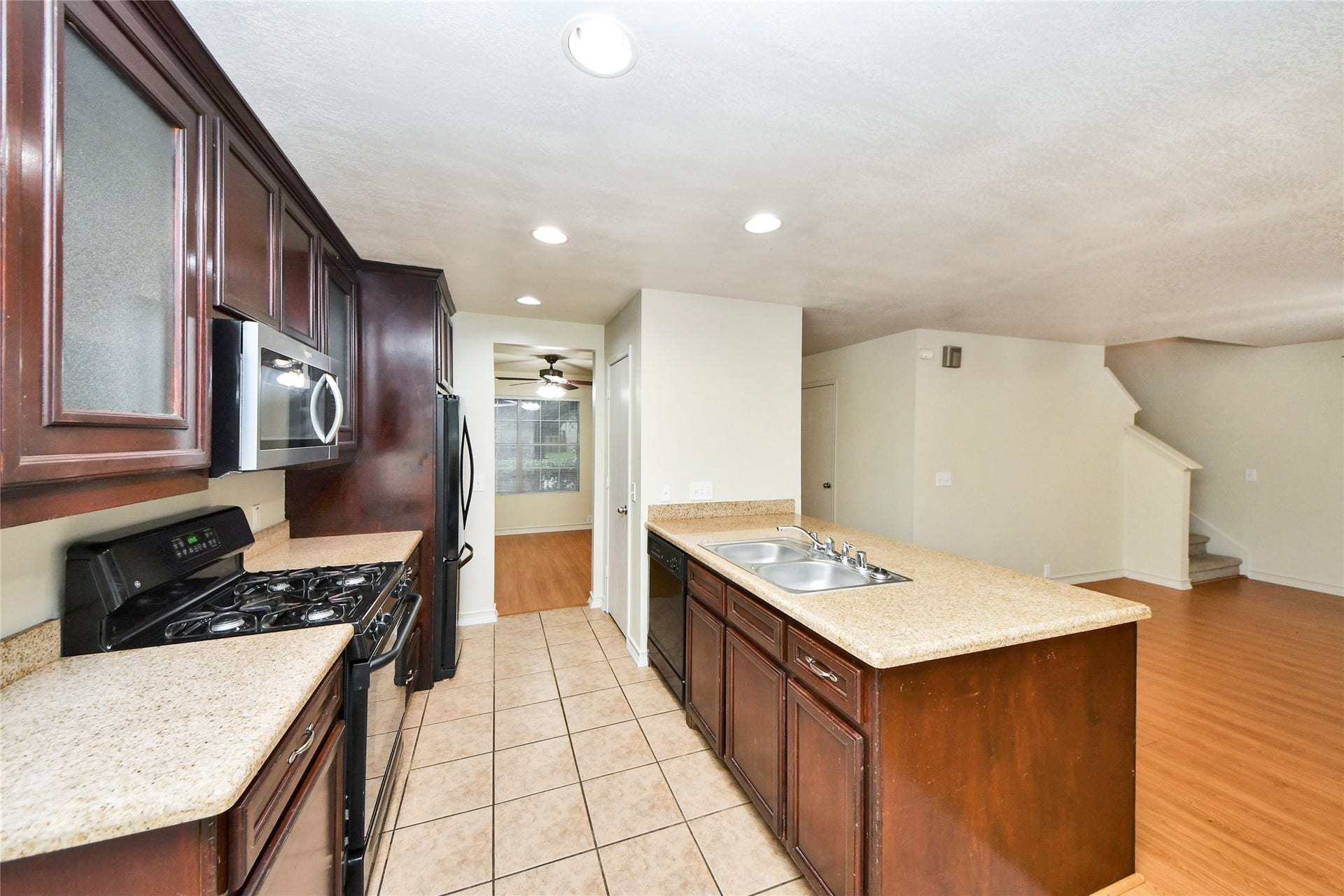 The kitchen boasts sleek dark cabinetry, modern appliances, and a spacious layout perfect for culinary creativity and seamless entertaining.