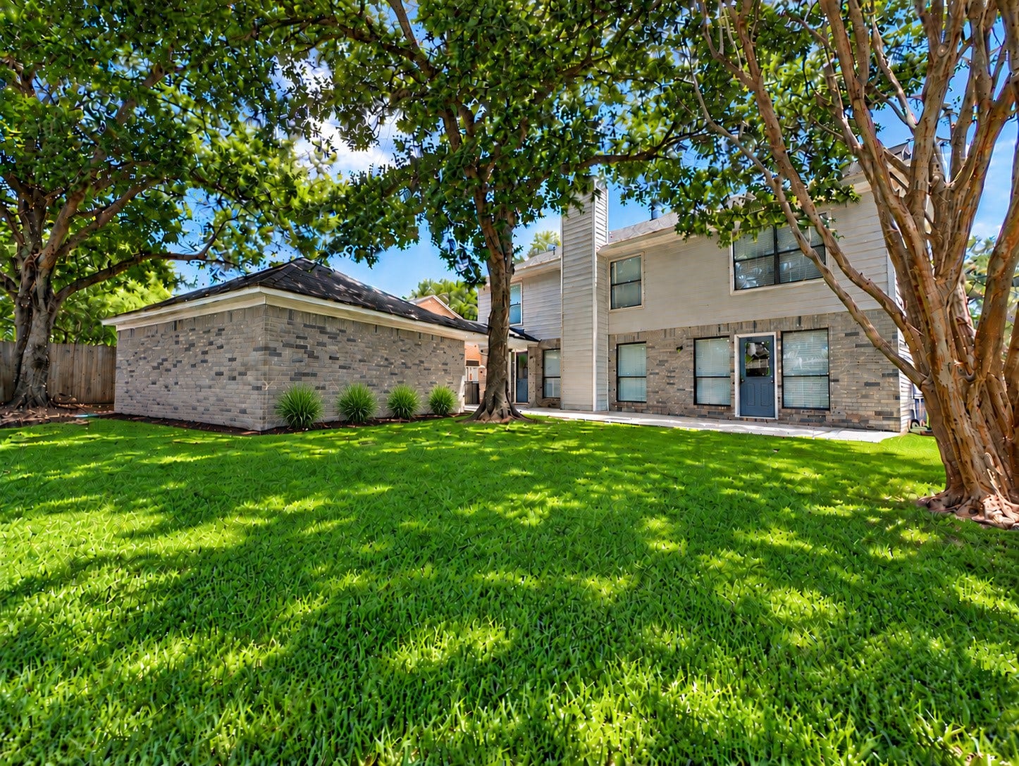 2102 Autumn Cove Drive, League City, TX 77573 Spacious backyard with mature shade trees, lush green lawn, and plenty of room for outdoor activities.