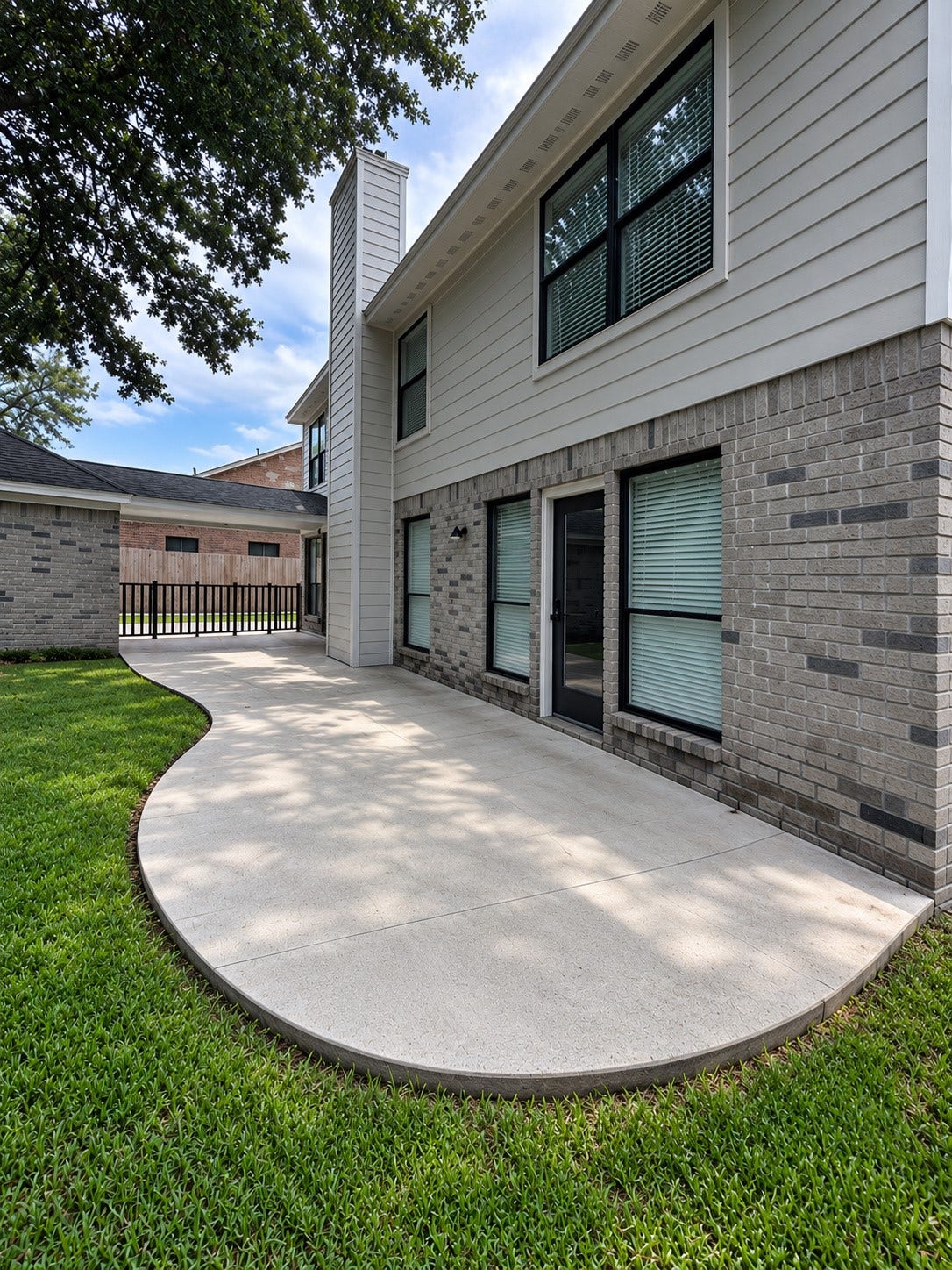 2102 Autumn Cove Drive, League City, TX 77573 Spacious curved concrete patio overlooking the backyard, shaded by mature trees.