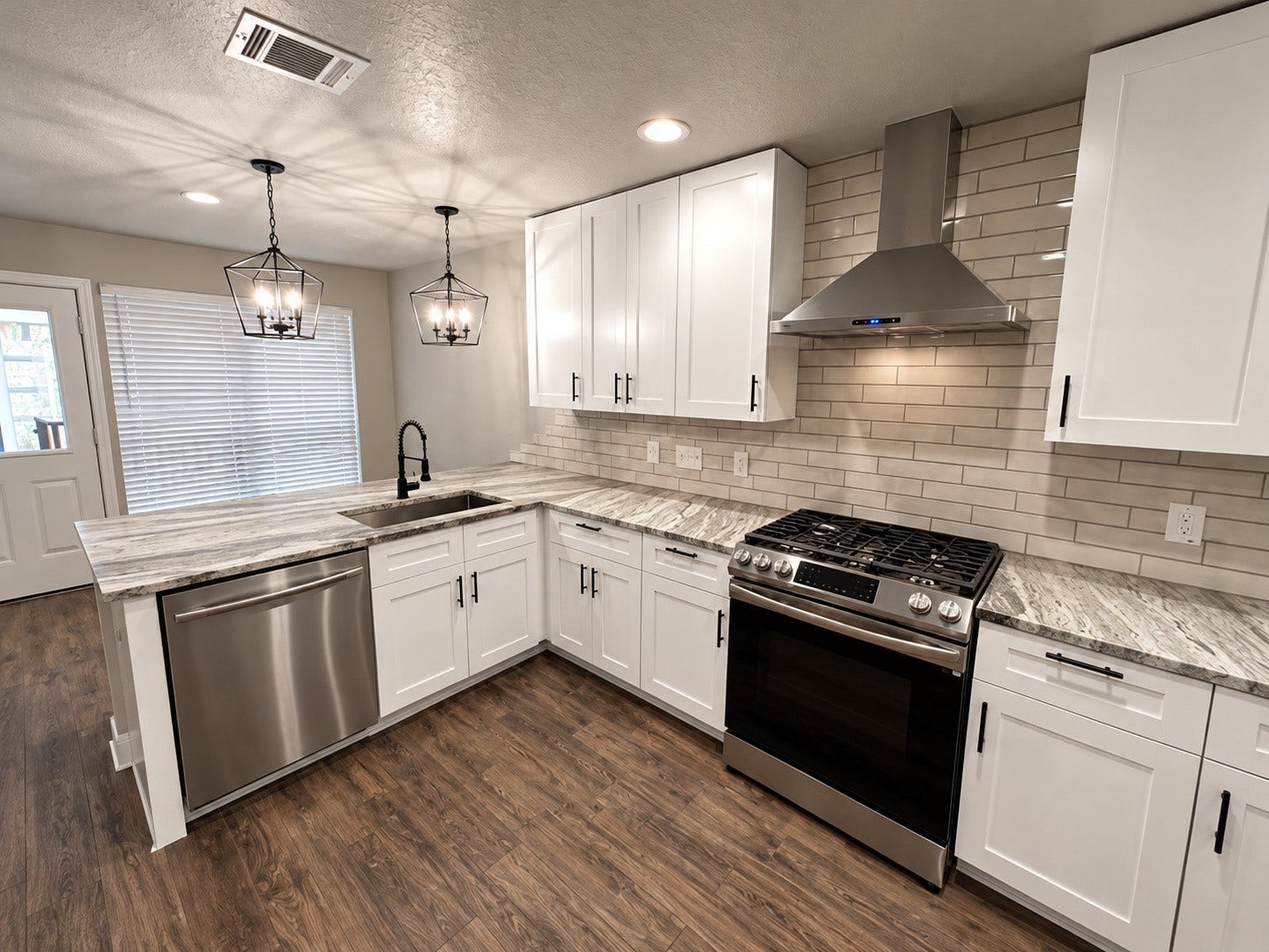 2102 Autumn Cove Drive, League City, TX 77573 Beautifully remodeled kitchen featuring white shaker cabinets, granite countertops, stainless steel appliances, and stylish modern lighting.