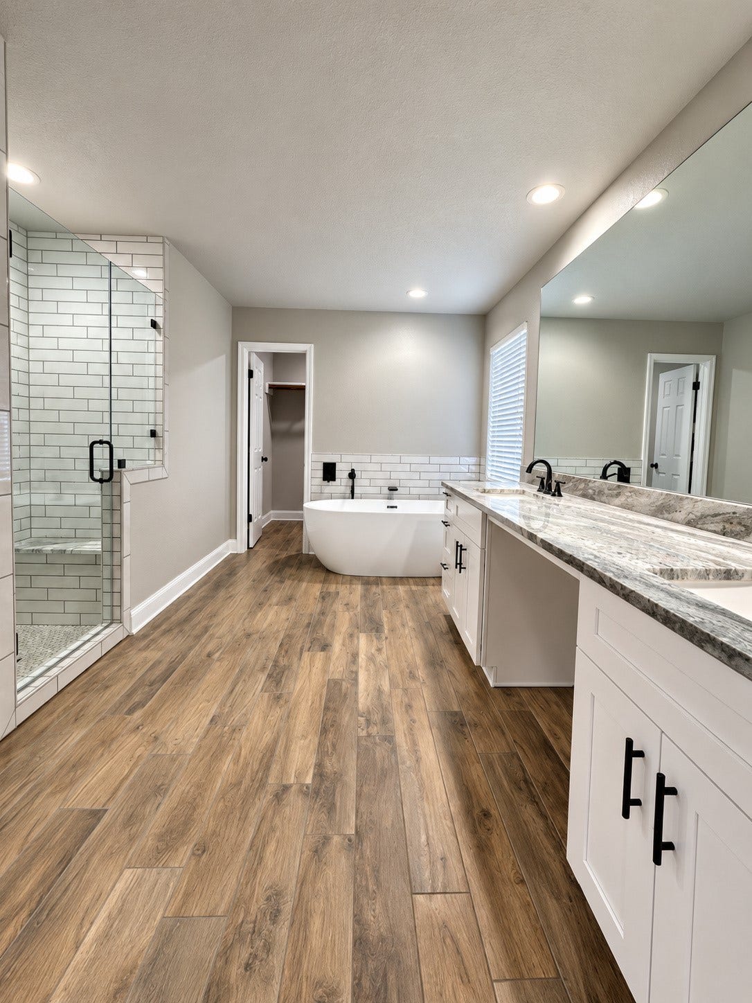 2102 Autumn Cove Drive, League City, TX 77573 Luxuriously renovated primary bathroom featuring a freestanding soaking tub, spacious walk-in shower, dual vanities, elegant modern finishes, and a large walk-in primary closet.