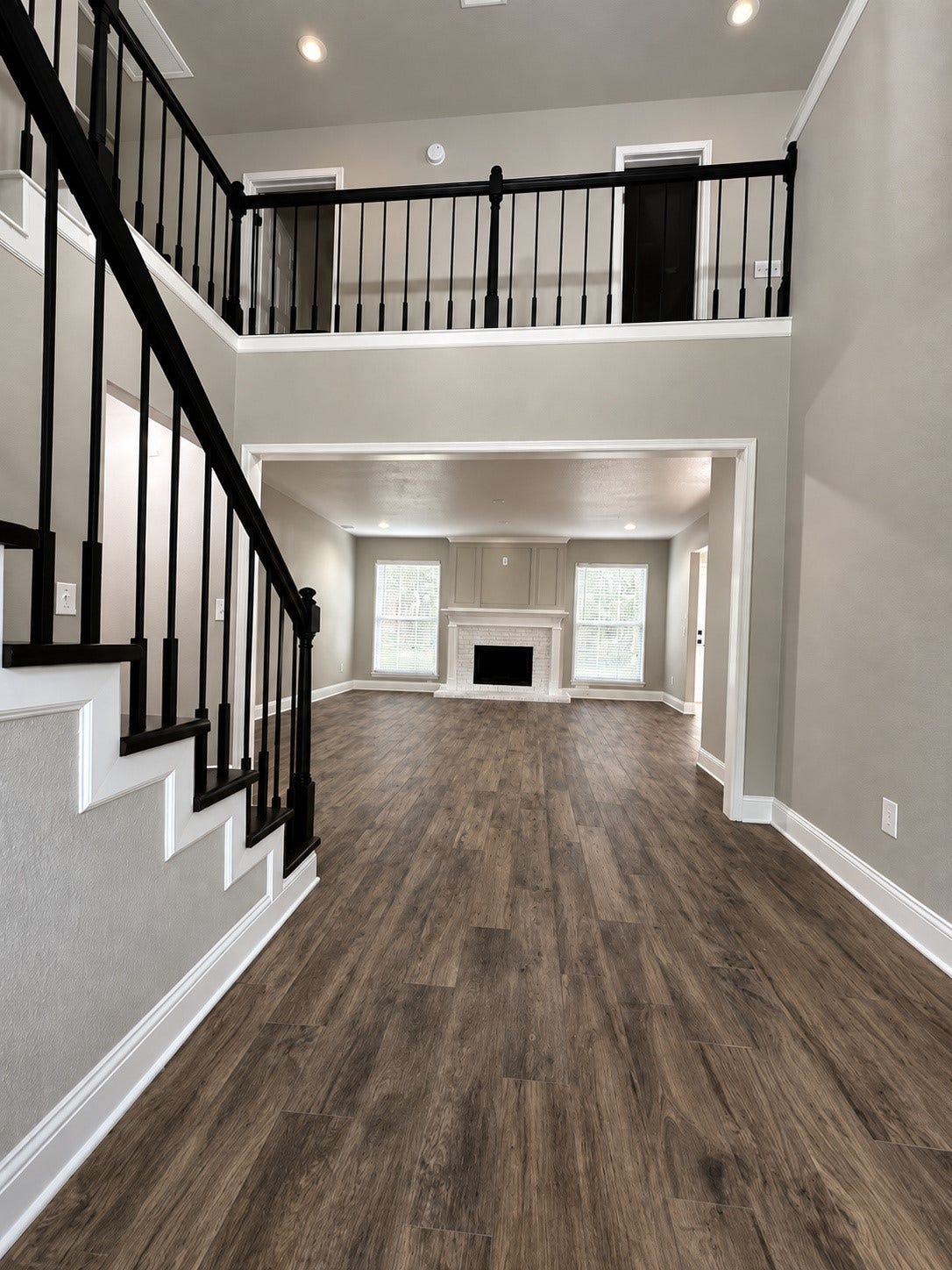 2102 Autumn Cove Drive, League City, TX 77573 Grand two-story entry featuring beautiful wood-look flooring, soaring ceilings, and elegant black stair railings.